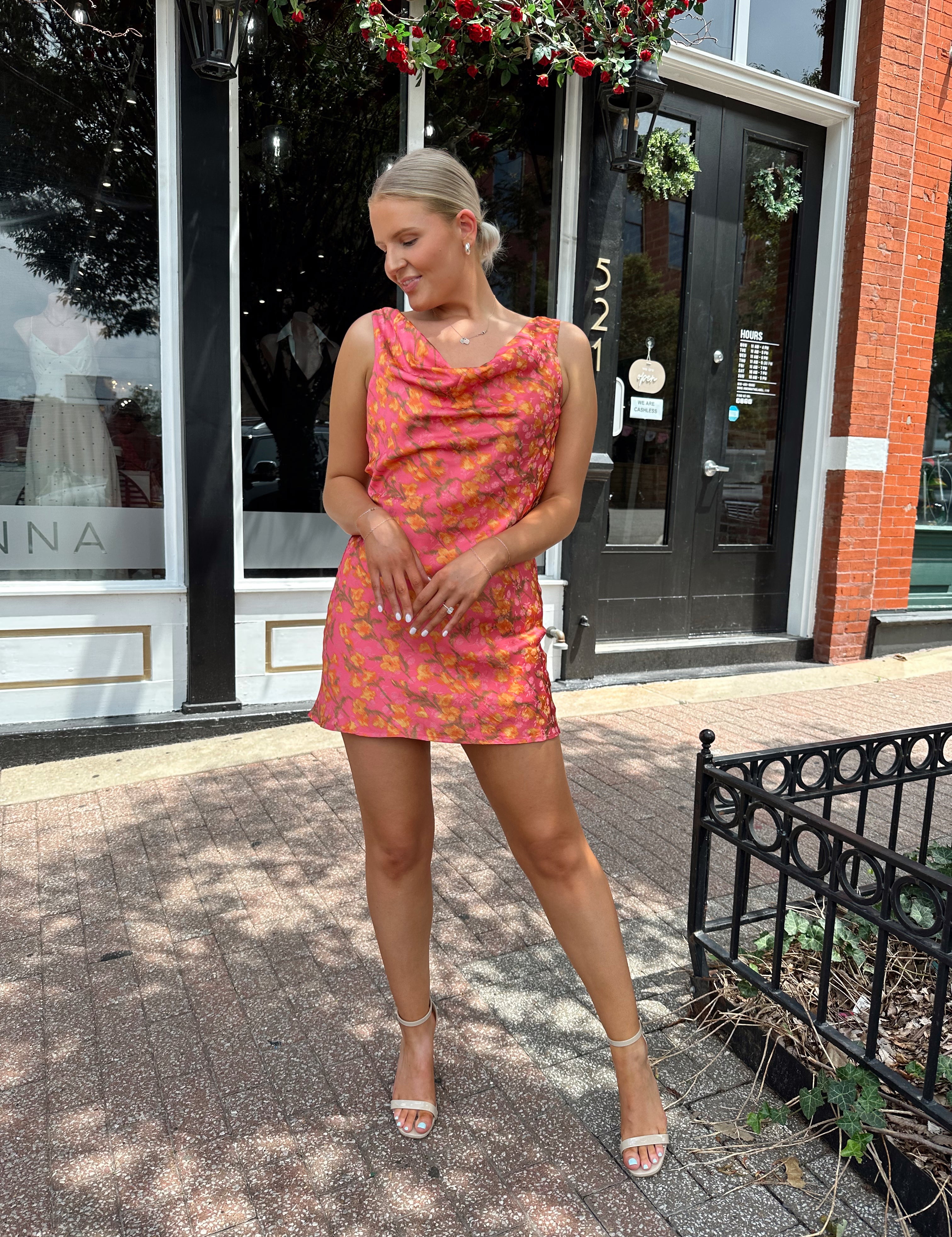 Hot pink satin mini dress with cowl neckline and rust colored floral pattern.