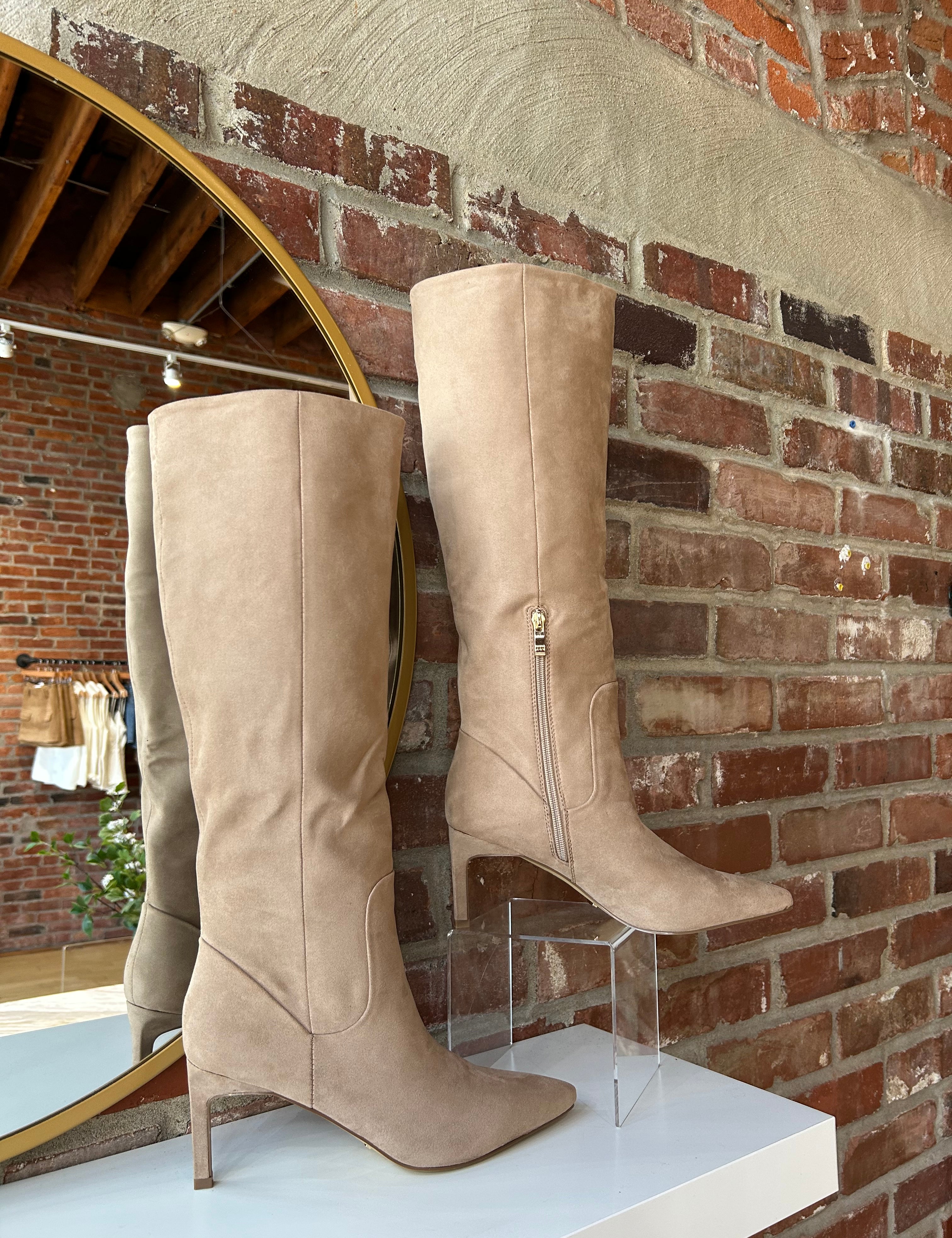 Tan suede knee-high boots with gold zipper hardware.