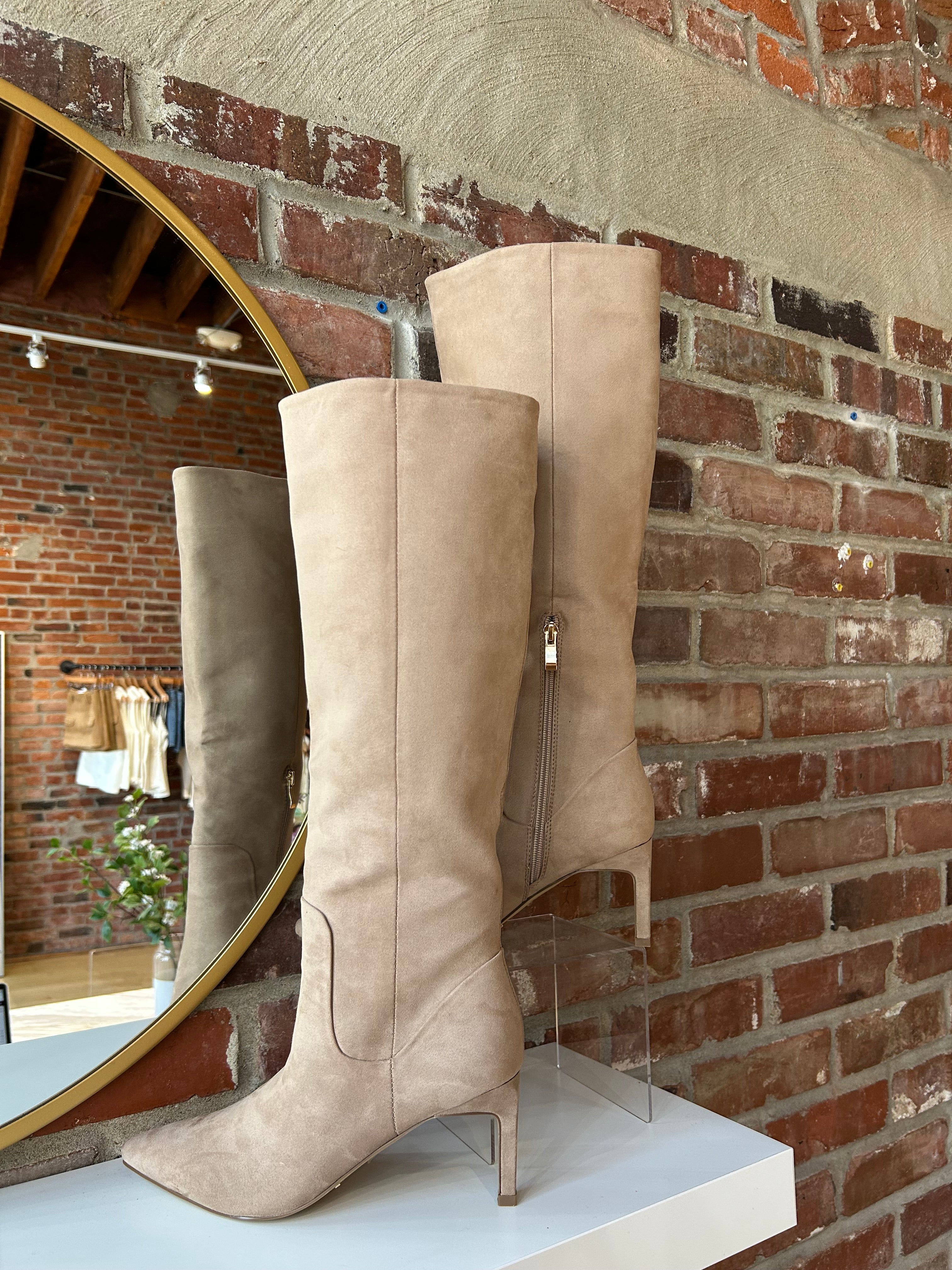 Tan suede knee-high boots with gold zipper hardware.