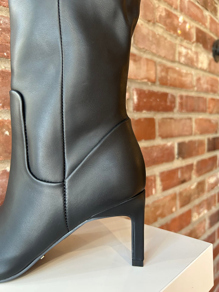 Tall black leather knee boot with inner zipper closure. 