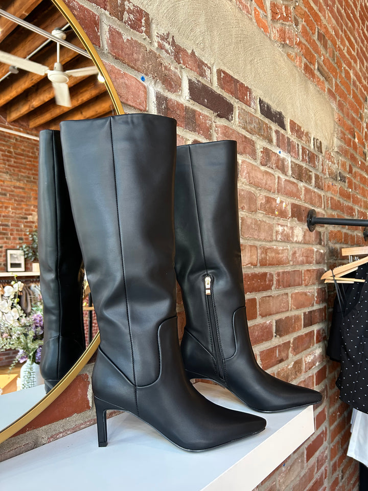Tall black leather knee boot with inner zipper closure. 