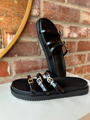 Billini Lacy Black Sandal with slim straps, gold buckles, and a cushioned sole for a modern, stylish, and comfortable fit