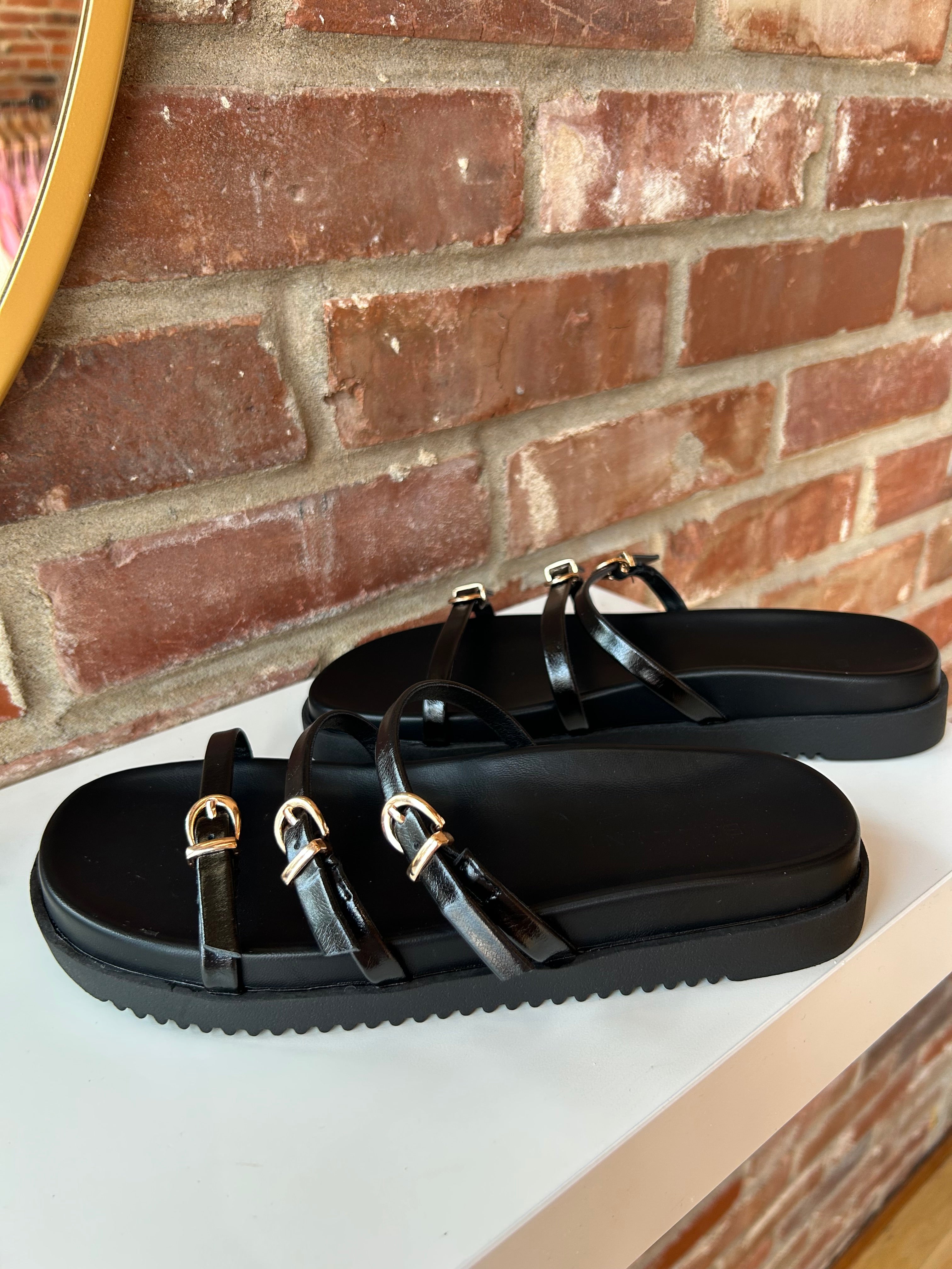 Billini Lacy Black Sandal with slim straps, gold buckles, and a cushioned sole for a modern, stylish, and comfortable fit