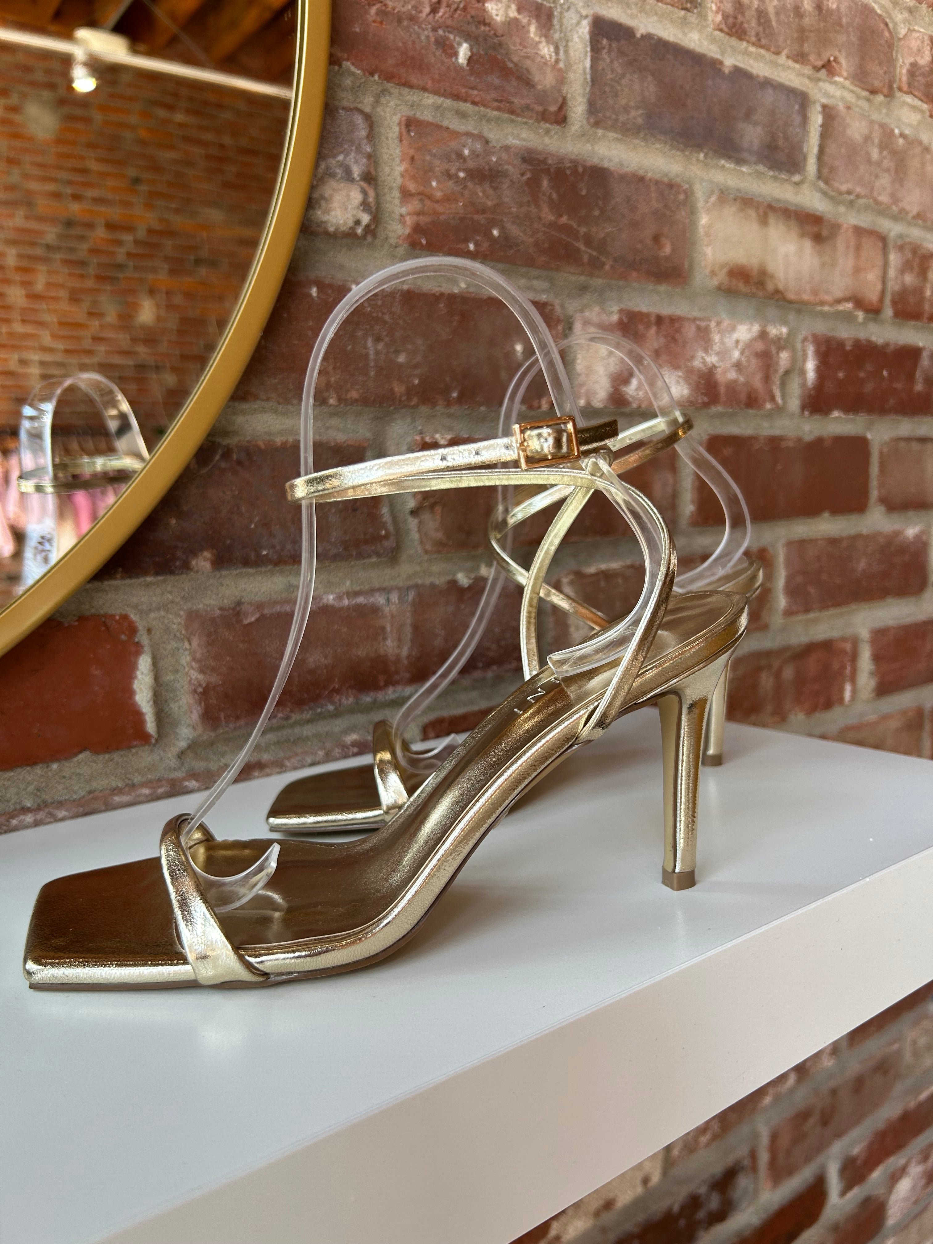 Alani Gold Strappy Heel with a metallic finish, slim straps, and a stiletto heel for an elegant and modern style.