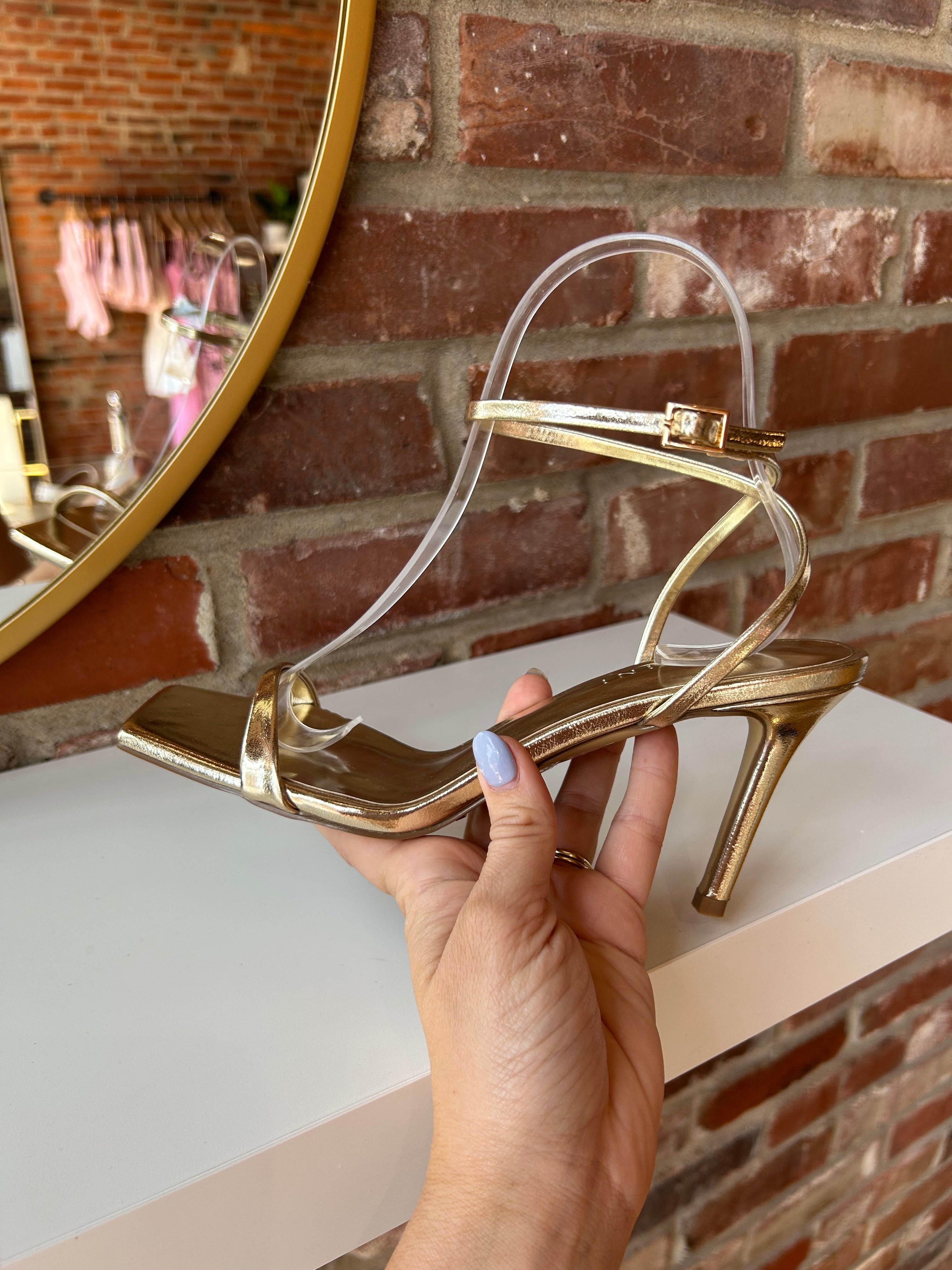 Alani Gold Strappy Heel with a metallic finish, slim straps, and a stiletto heel for an elegant and modern style.
