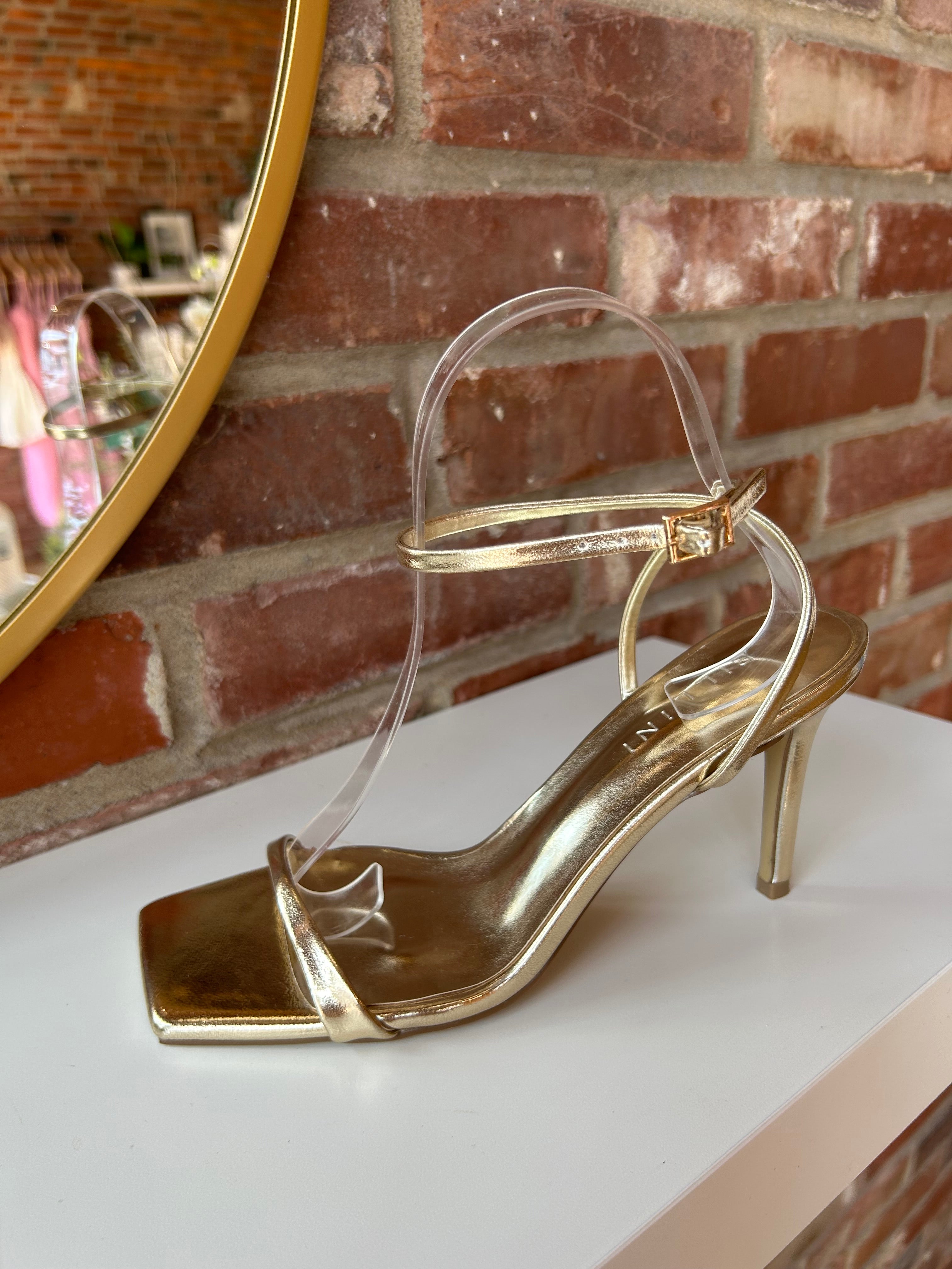 Alani Gold Strappy Heel with a metallic finish, slim straps, and a stiletto heel for an elegant and modern style.