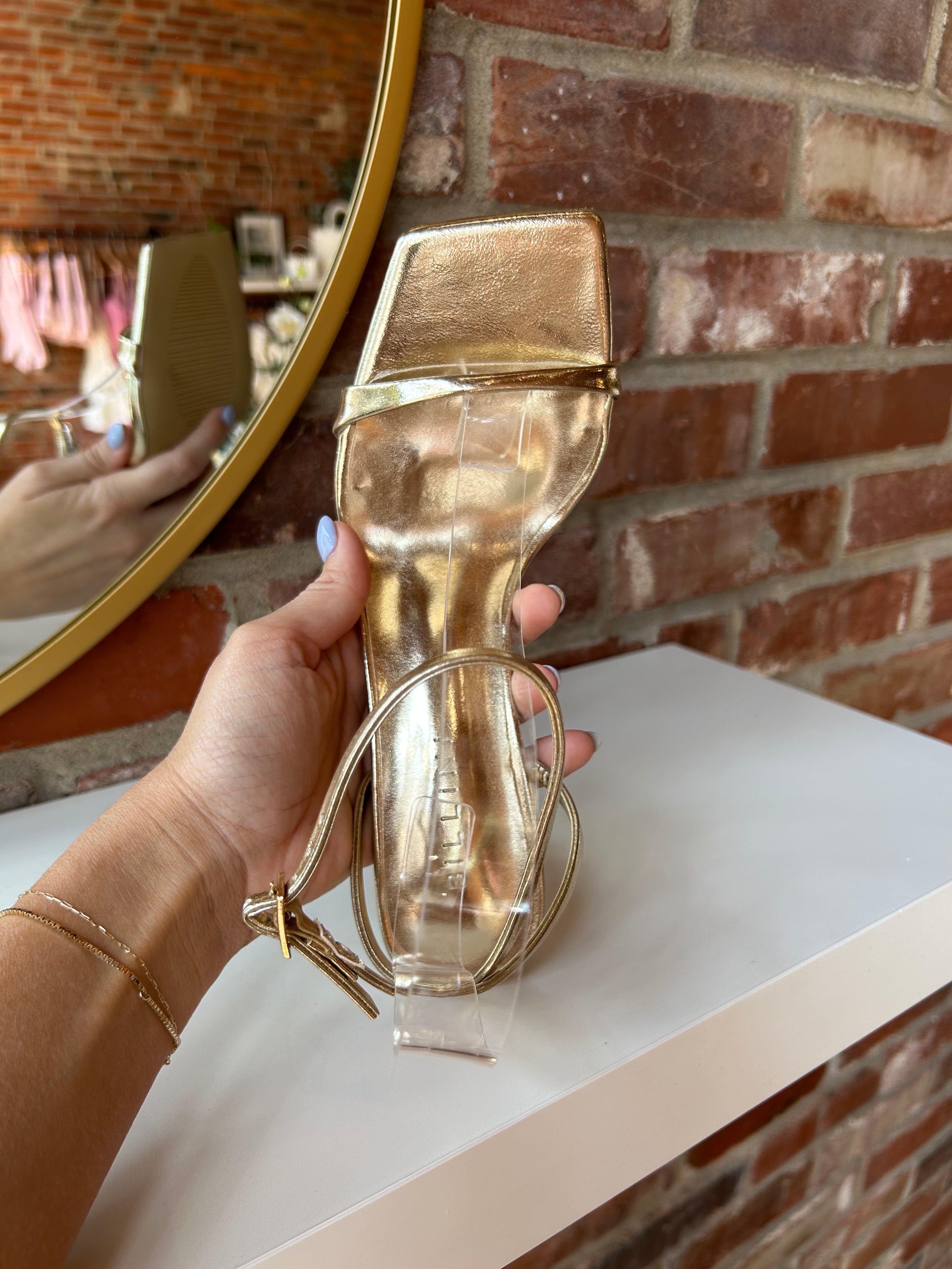 Alani Gold Strappy Heel with a metallic finish, slim straps, and a stiletto heel for an elegant and modern style.