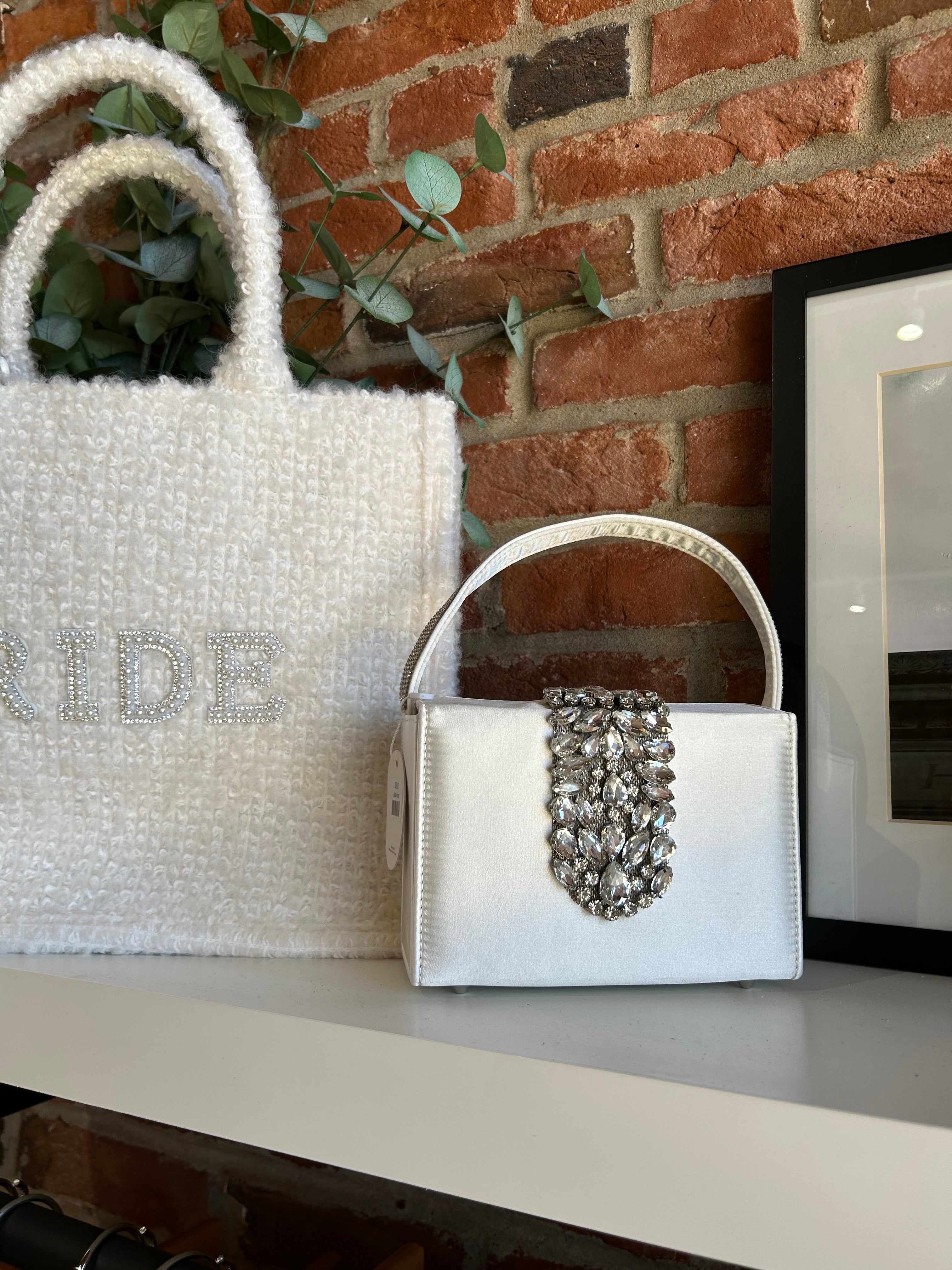 Liliana Purse with a satin finish, rhinestone embellishments, and a structured top handle for a chic and elegant look.