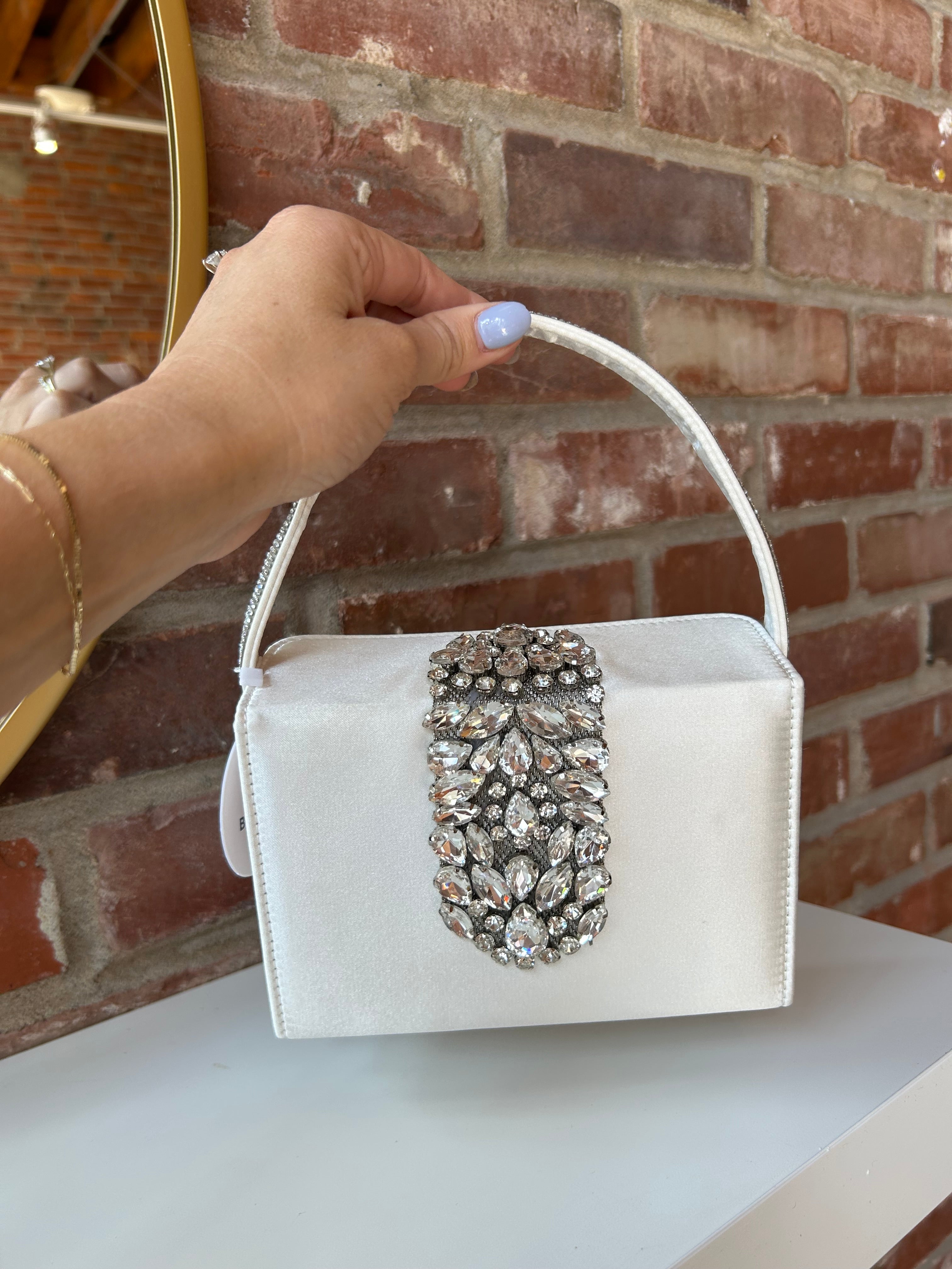Liliana Purse with a satin finish, rhinestone embellishments, and a structured top handle for a chic and elegant look.