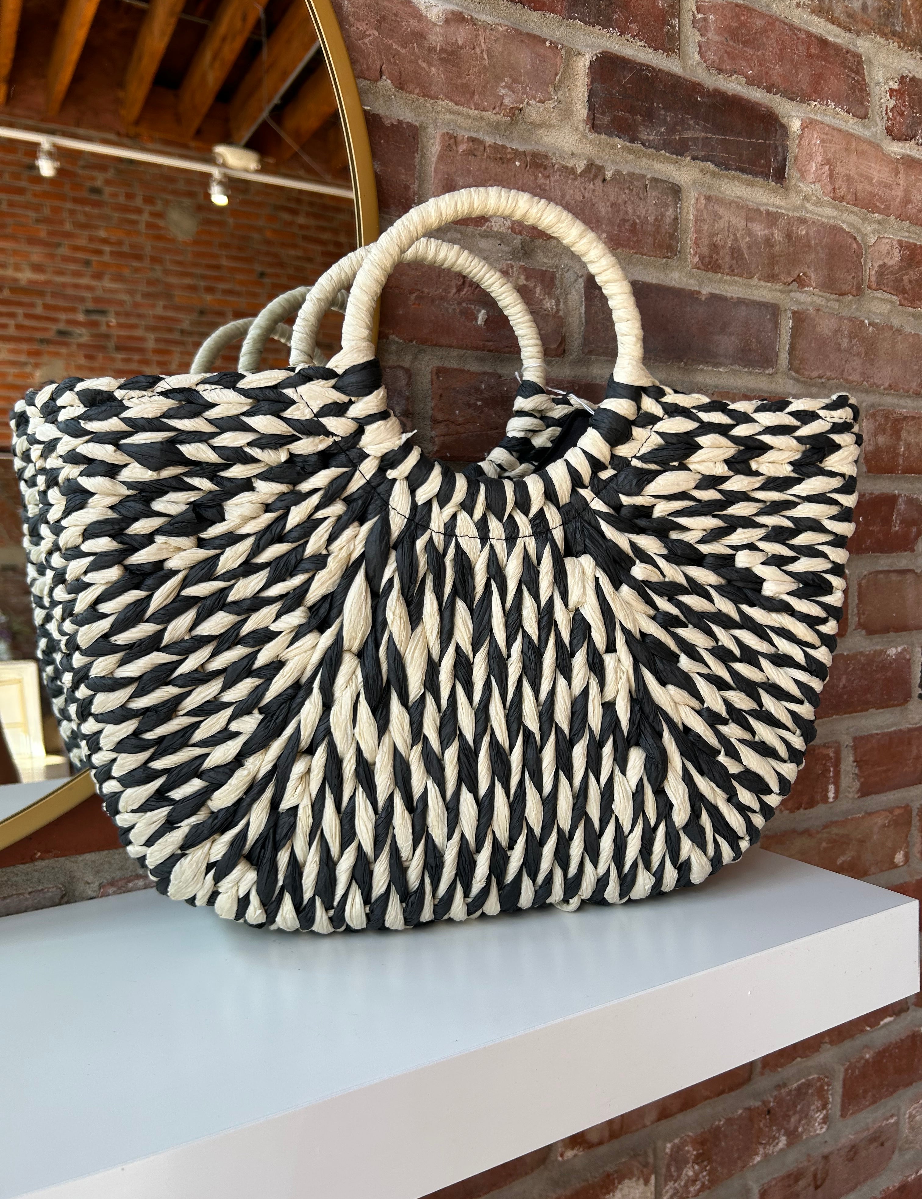 Black and tan straw woven tote bag. Perfect for vacation or carrying all summer. 