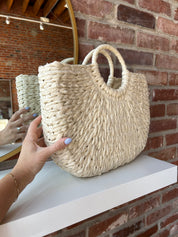 Beige straw woven tote bag. Perfect for vacation or carrying all summer. 