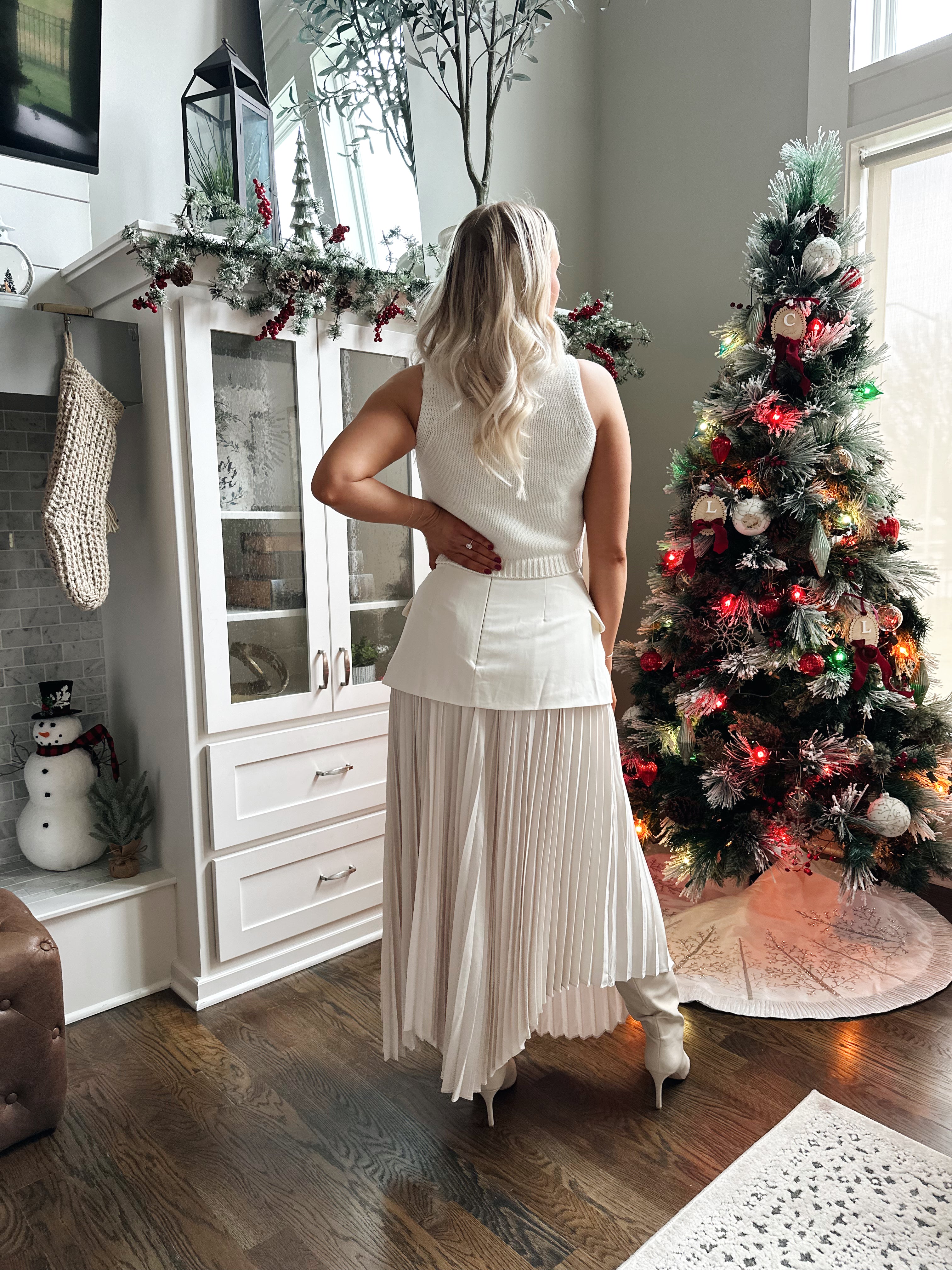 Woman wearing ivory asymmetrical maxi skirt with plated bottom.