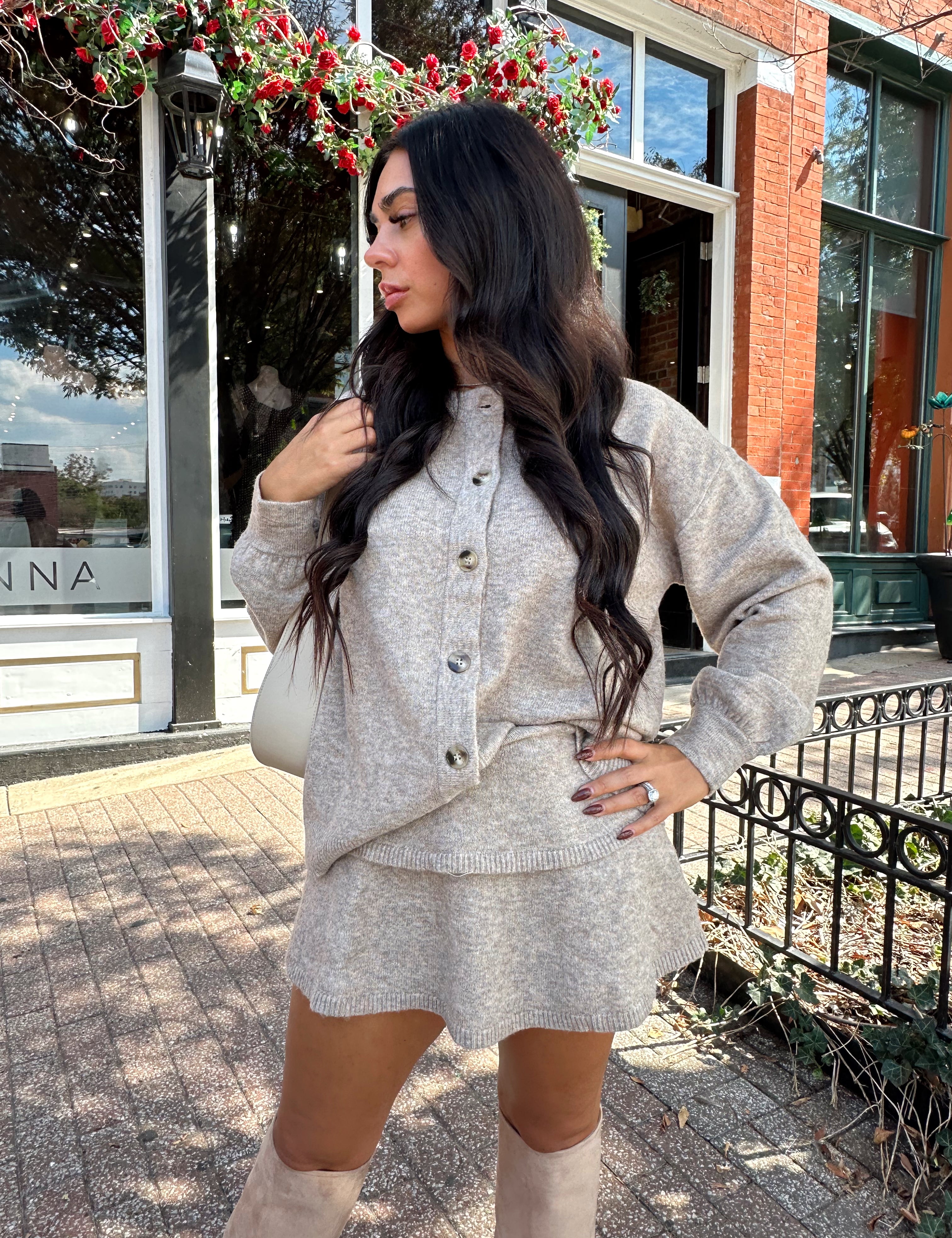 Woman wearing two piece sweater set with button down detailing, and built in shorts. 