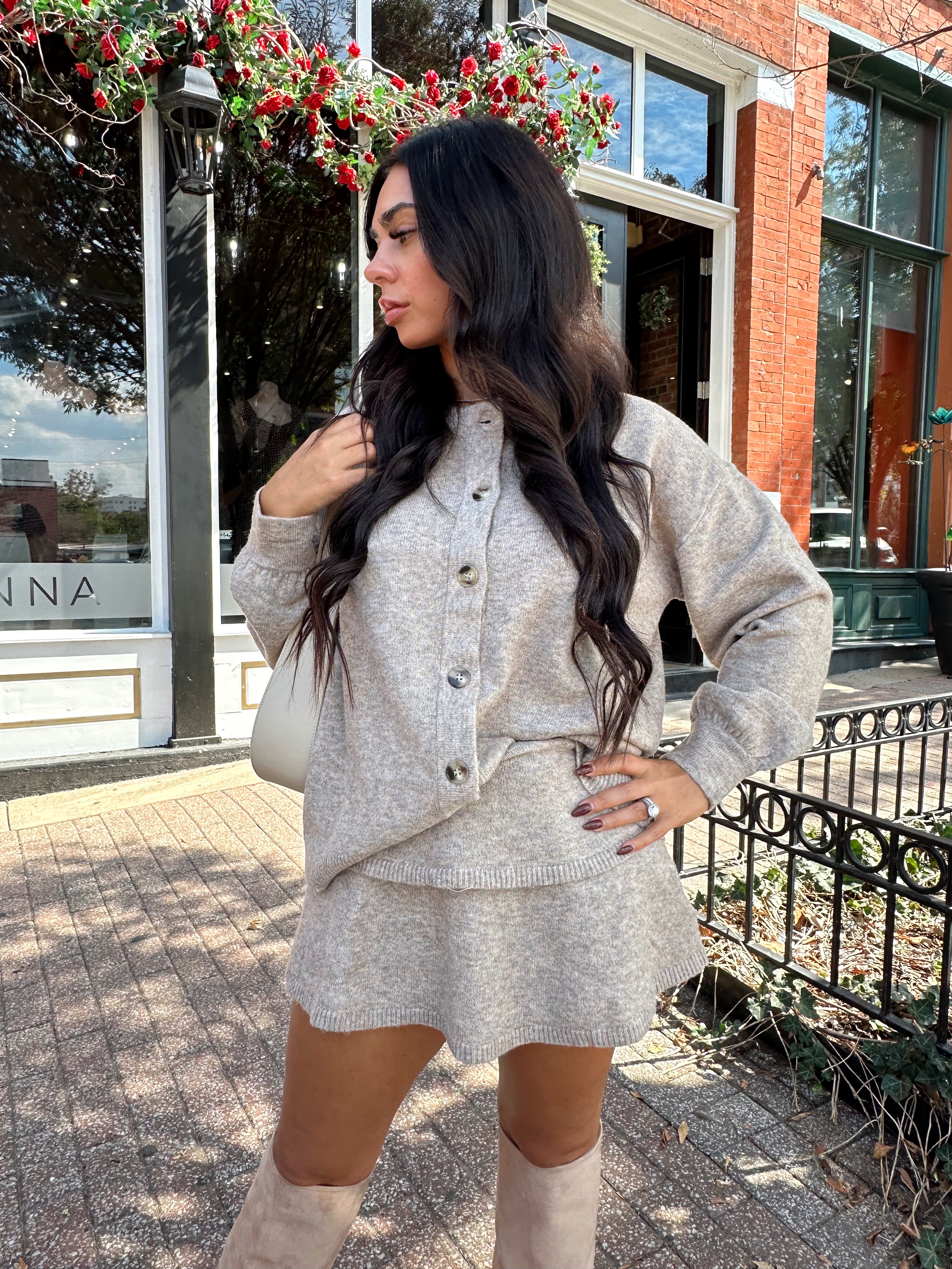 Woman wearing two piece sweater set with button down detailing, and built in shorts. 