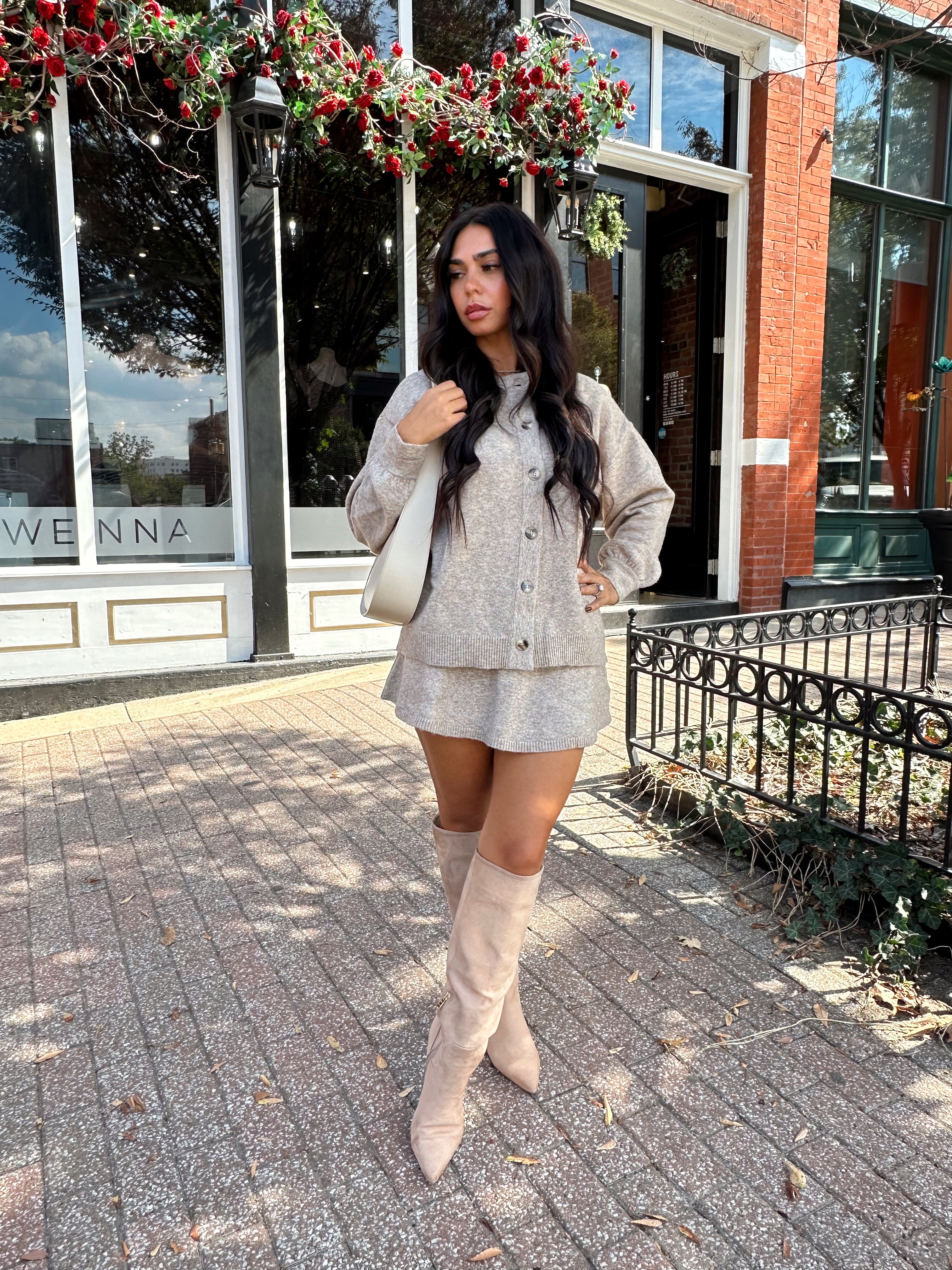 Woman wearing two piece sweater set with button down detailing, and built in shorts. 