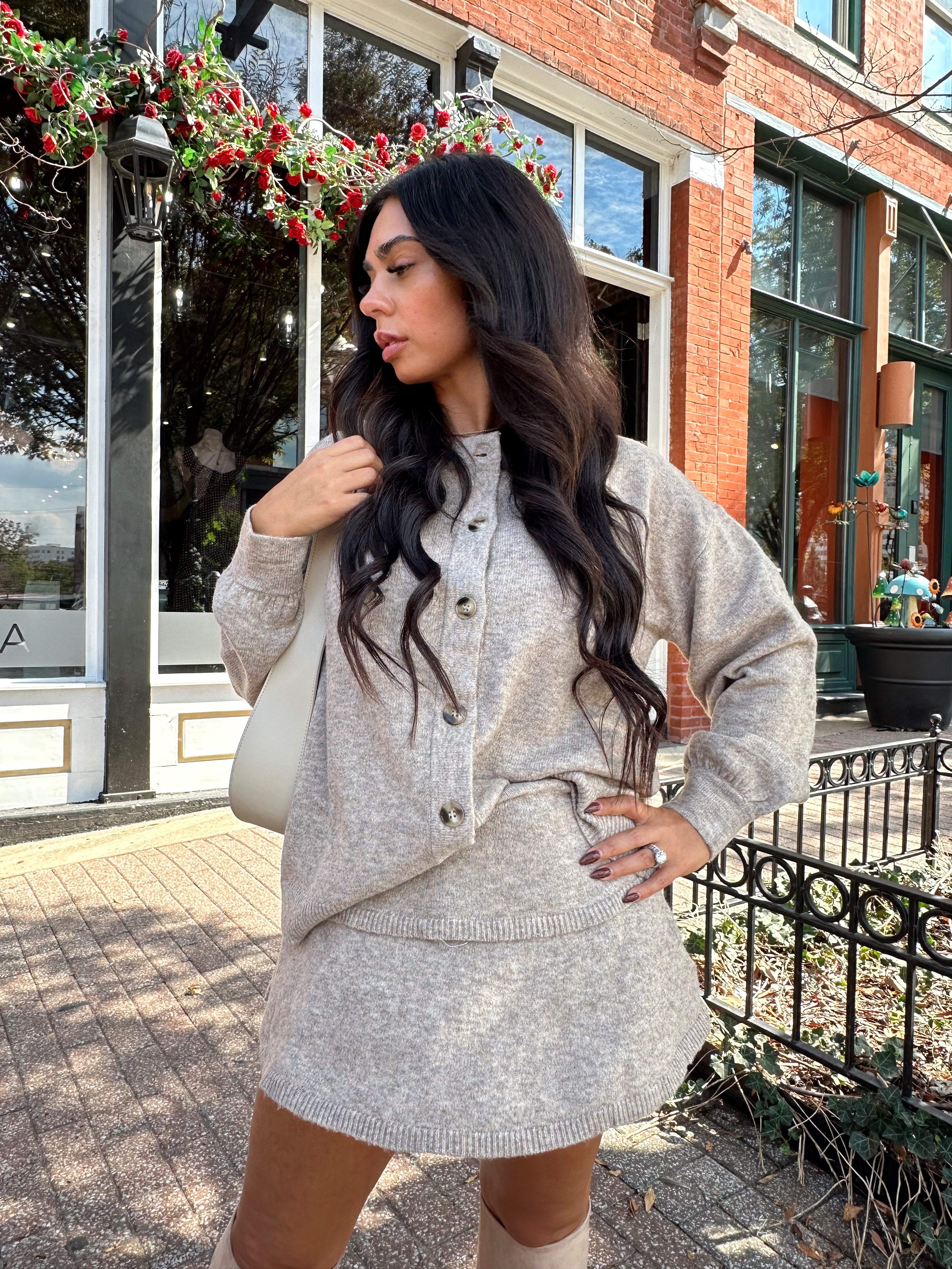 Woman wearing two piece sweater set with button down detailing, and built in shorts. 