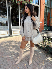 Woman wearing two piece sweater set with button down detailing, and built in shorts. 