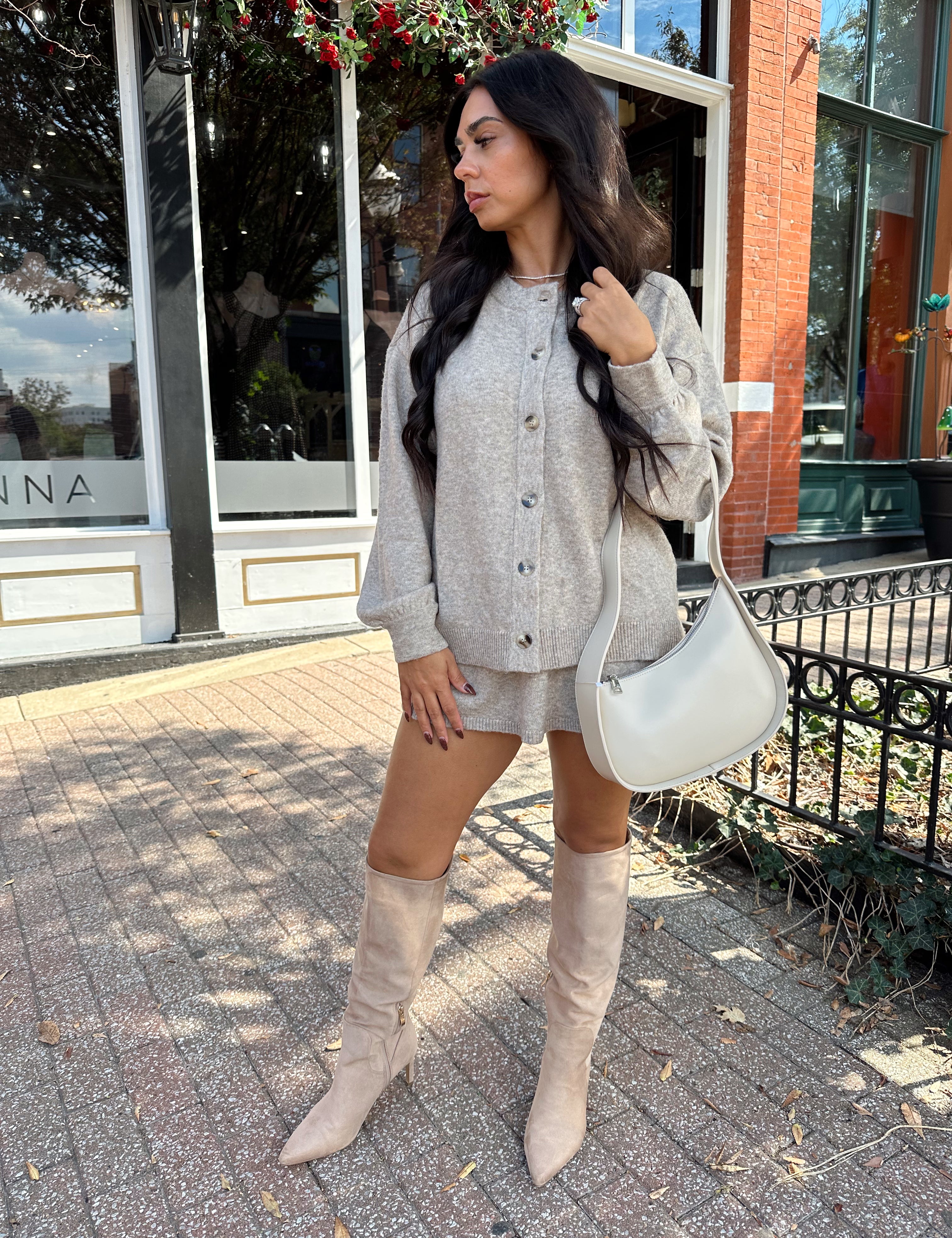 Woman wearing two piece sweater set with button down detailing, and built in shorts. 