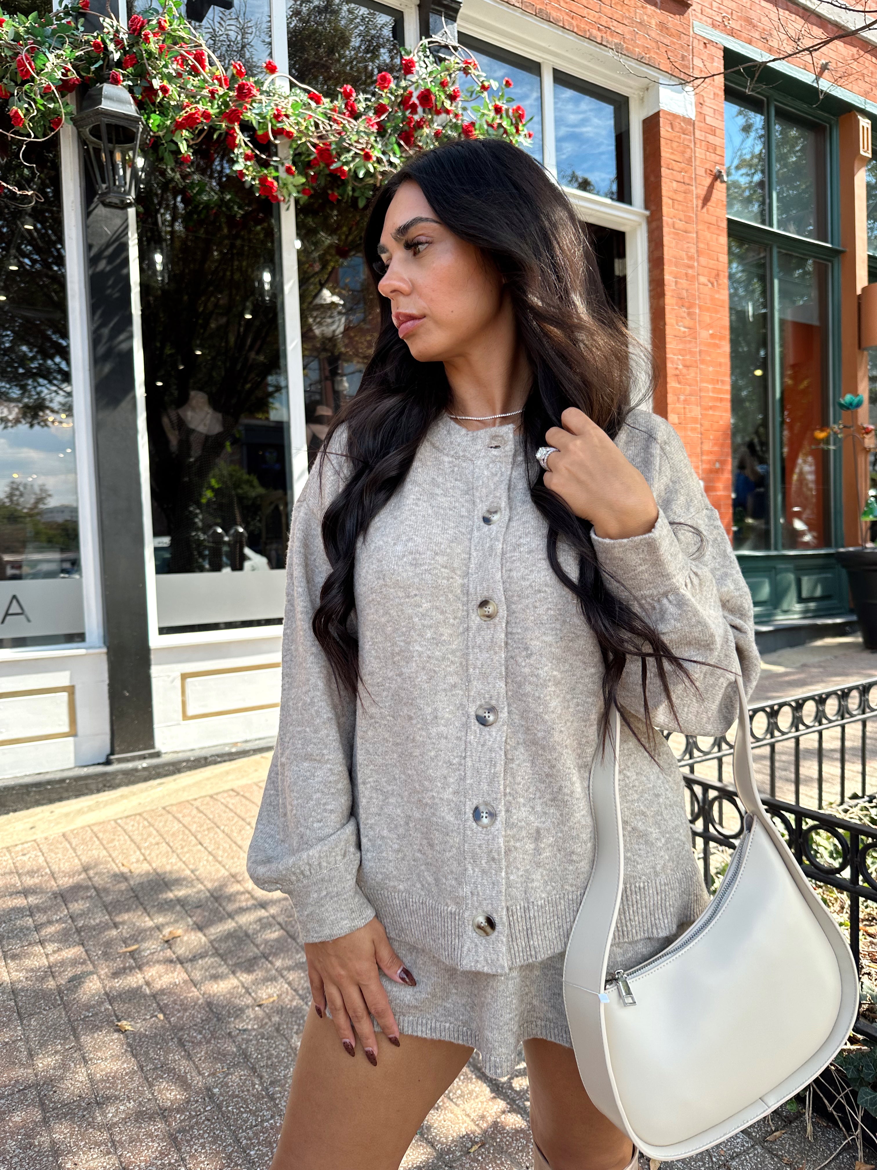 Woman wearing two piece sweater set with button down detailing, and built in shorts. 