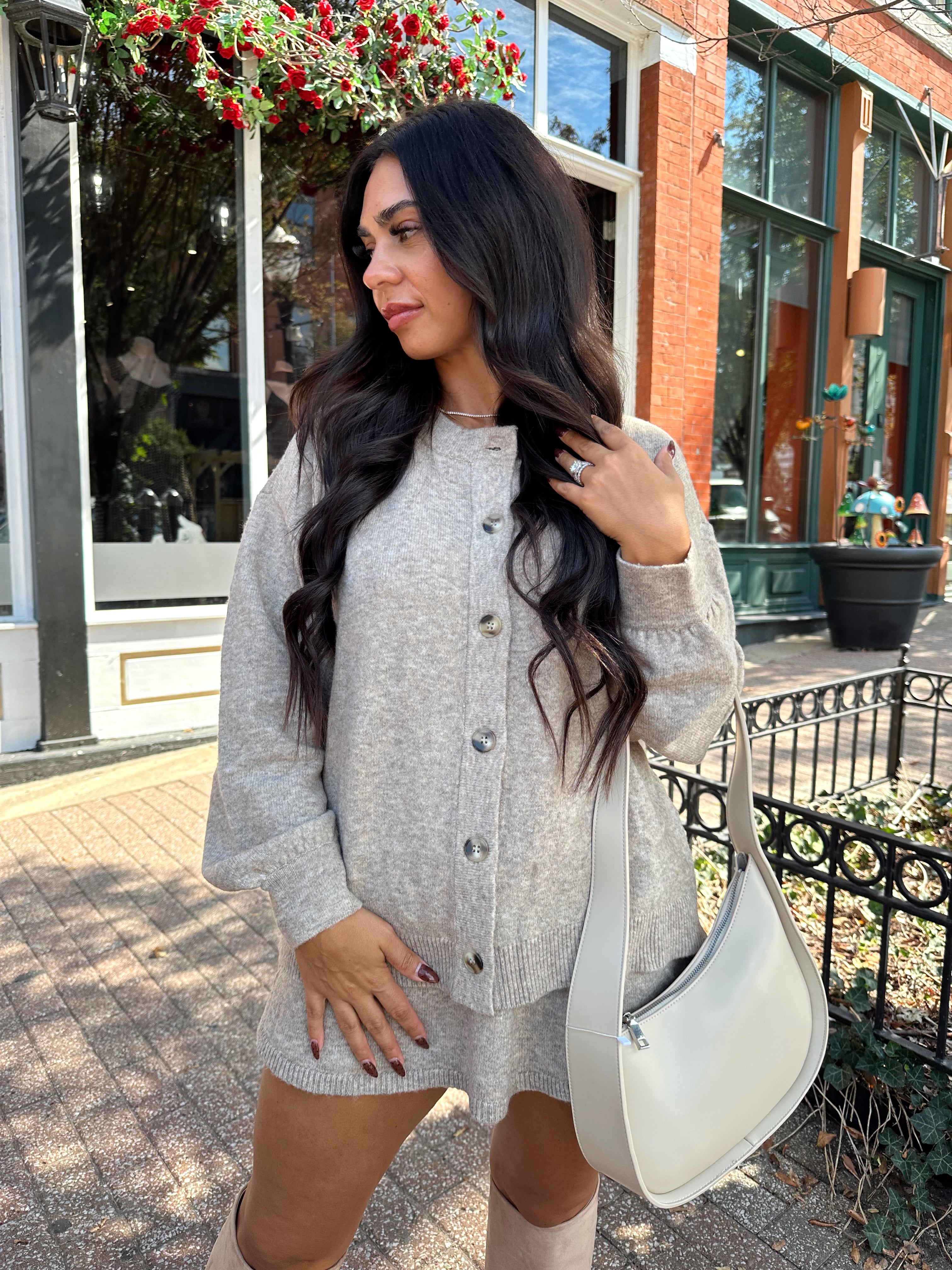 Woman wearing two piece sweater set with button down detailing, and built in shorts. 