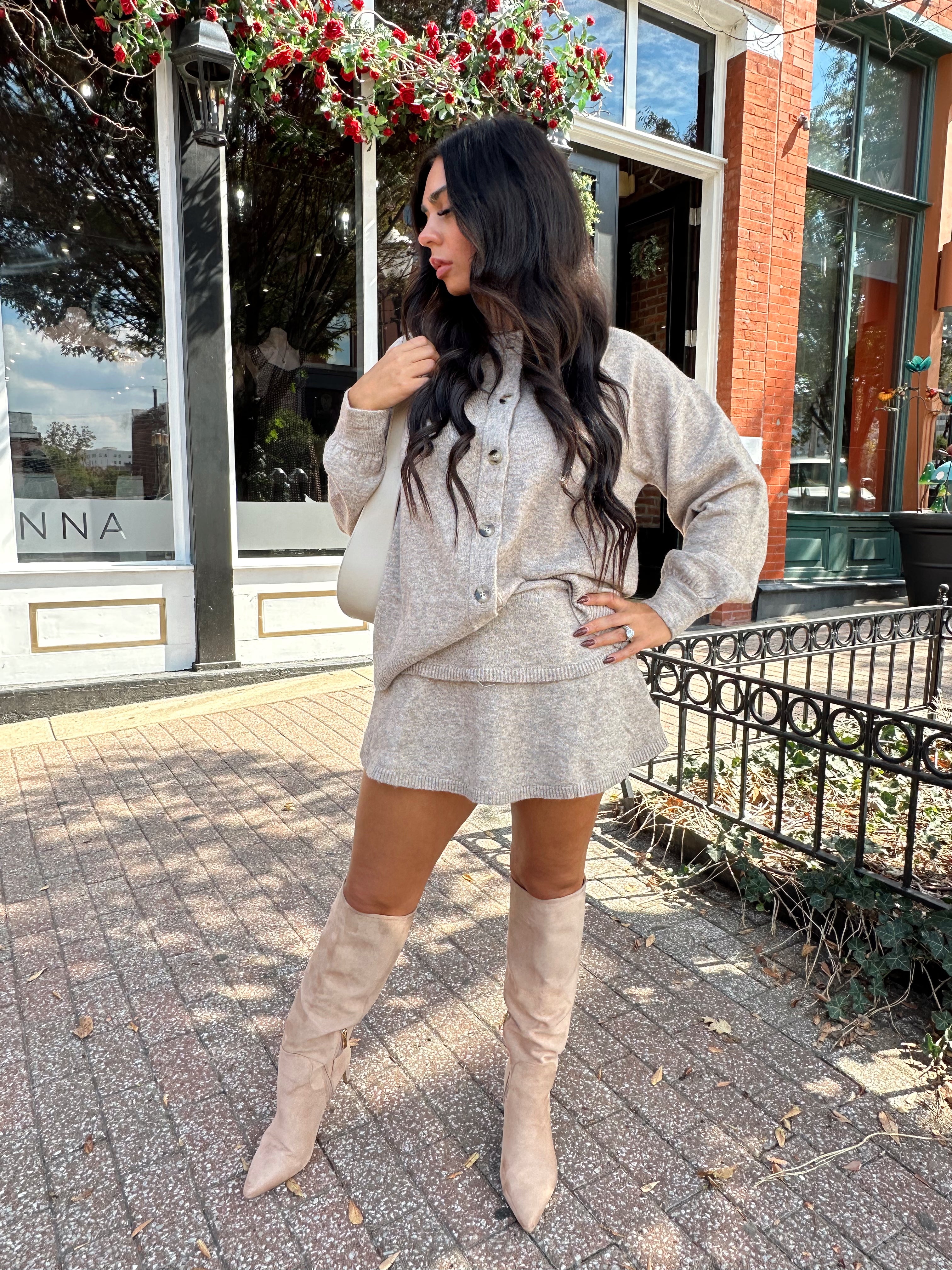 Woman wearing two piece sweater set with button down detailing, and built in shorts. 