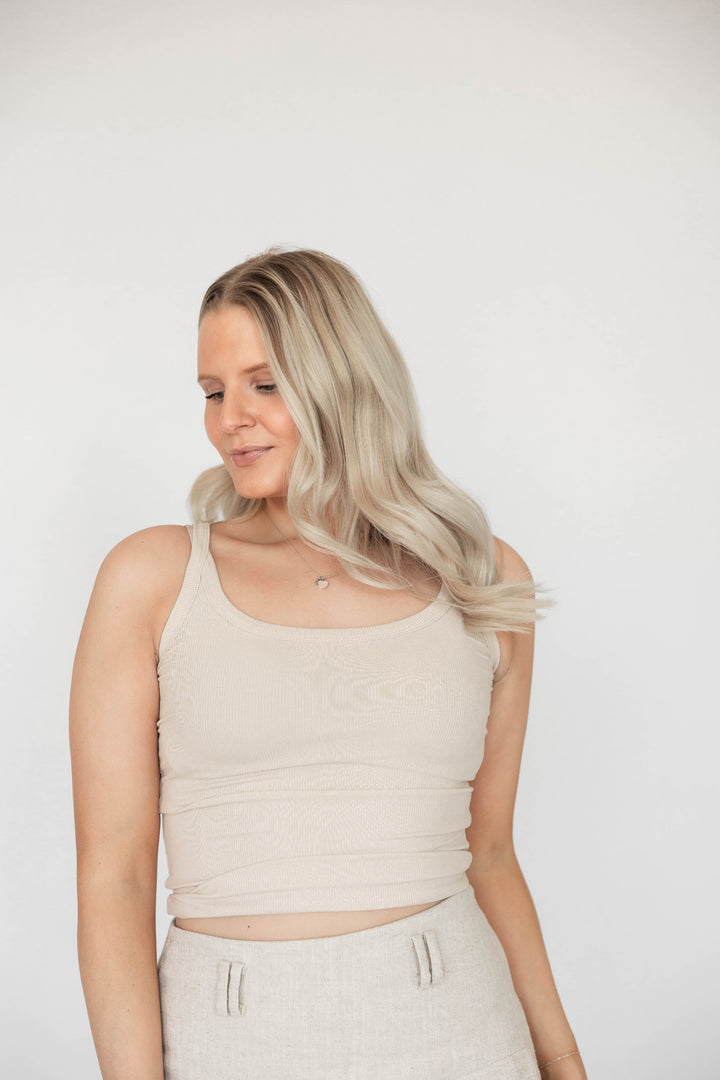 Woman wearing tan ribbed tank top.