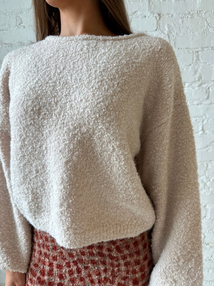 Woman wearing beige knit sweater with burgundy textured dotted maxi skirt.