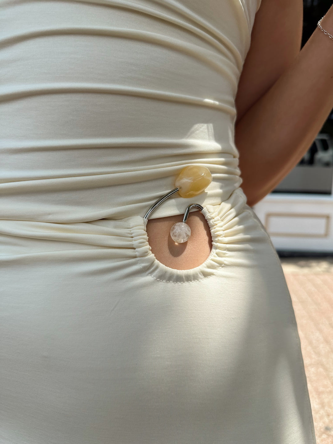 Woman wearing cream two piece set with maxi skirt with ring beaded detailing. 