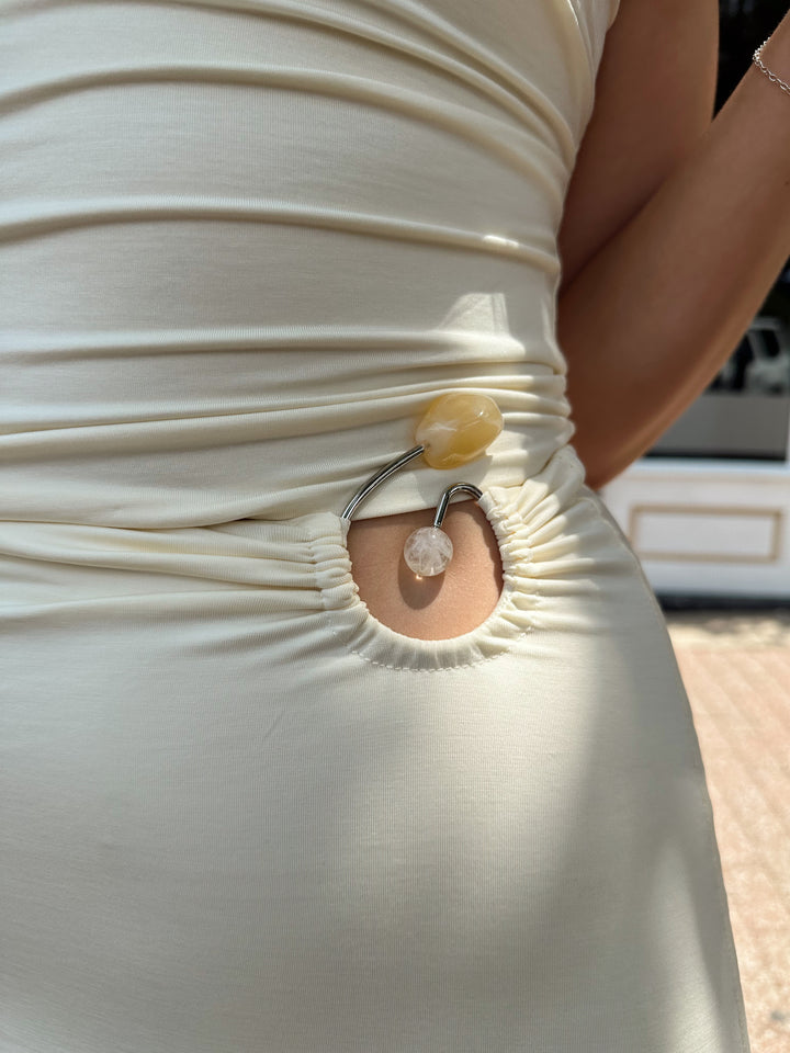 Woman wearing cream two piece set with maxi skirt with ring beaded detailing. 