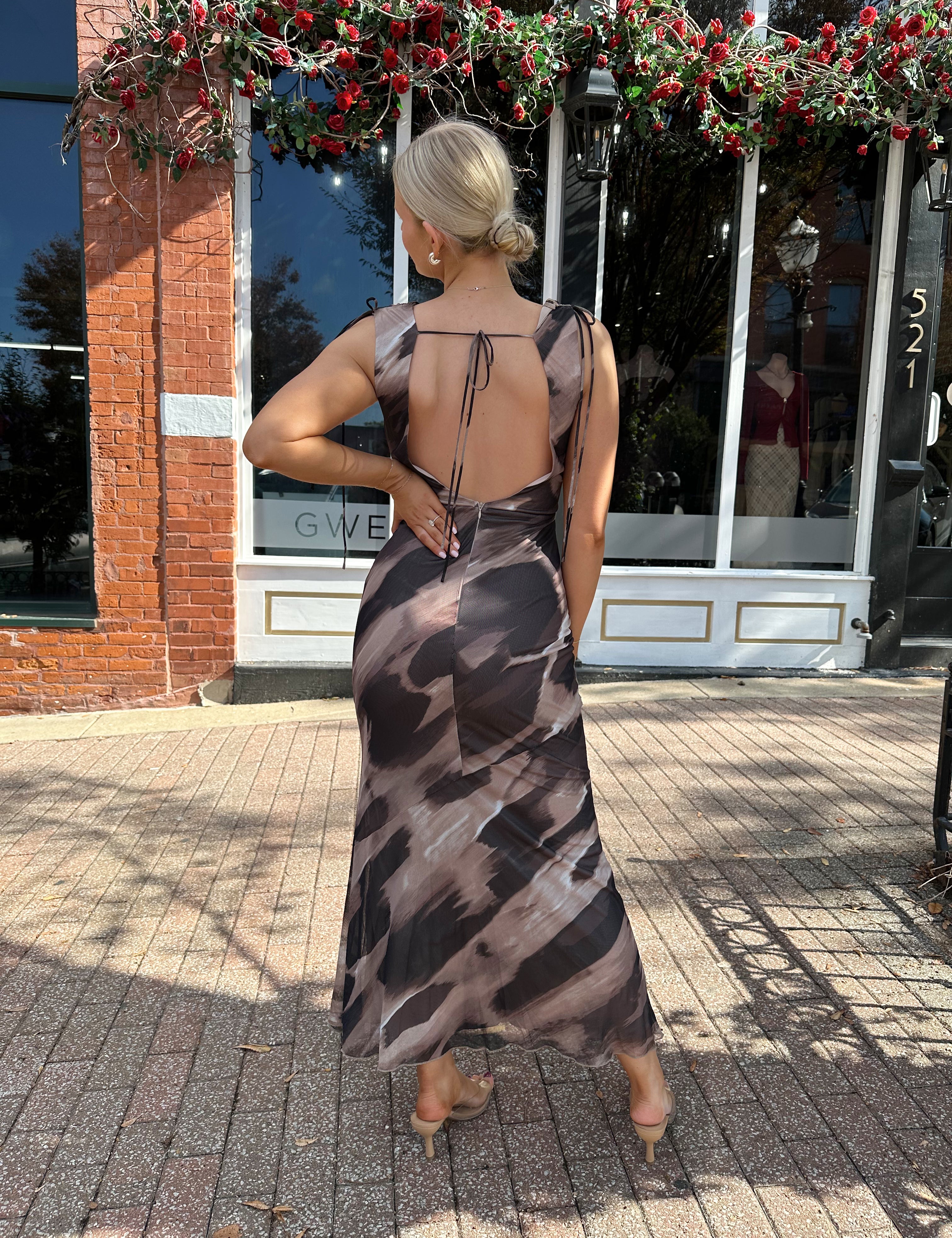 Woman wearing brown abstract pattern mesh midi dress with cowl neck and open back.