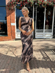 Woman wearing brown abstract pattern mesh midi dress with cowl neck and open back.