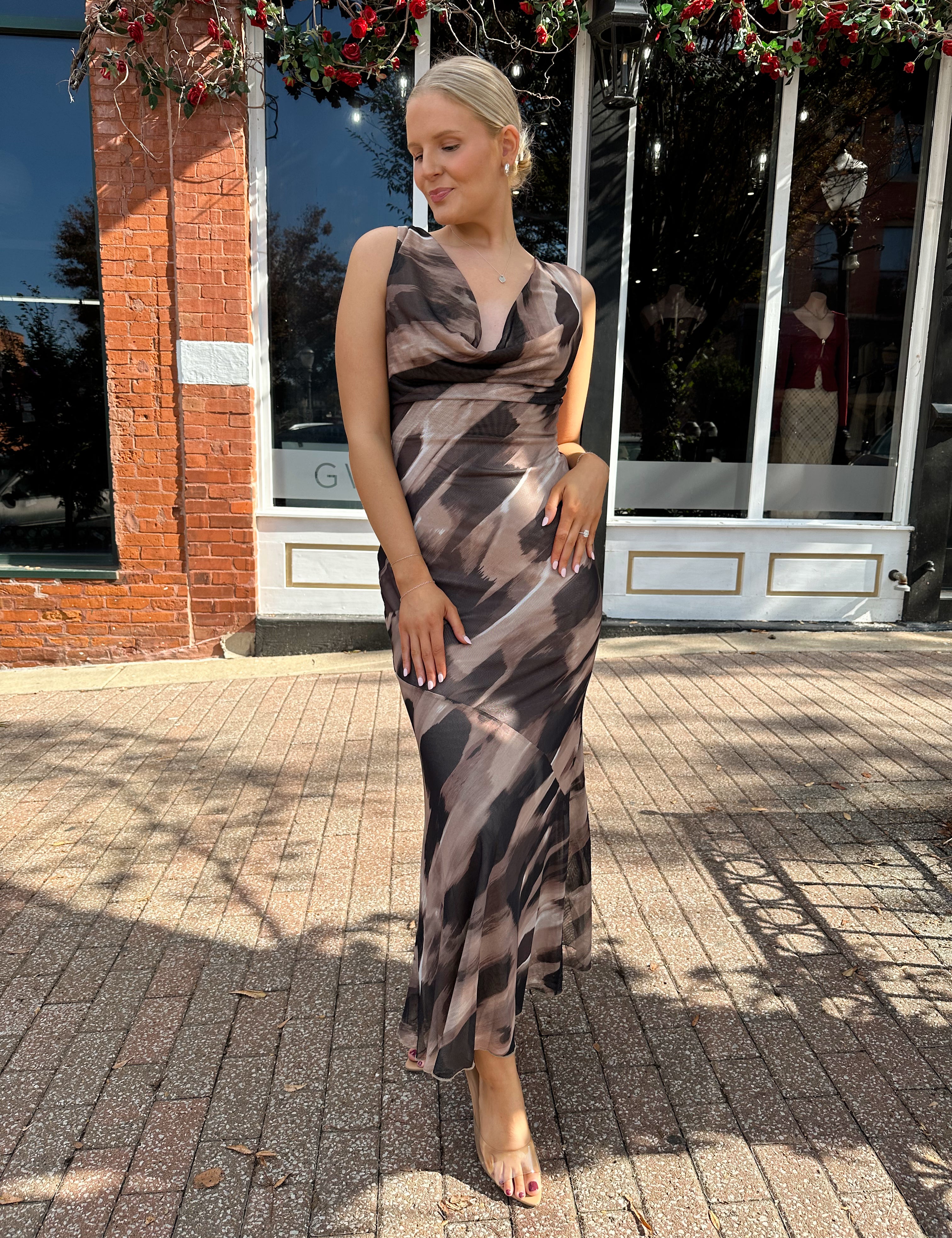 Woman wearing brown abstract pattern mesh midi dress with cowl neck and open back.