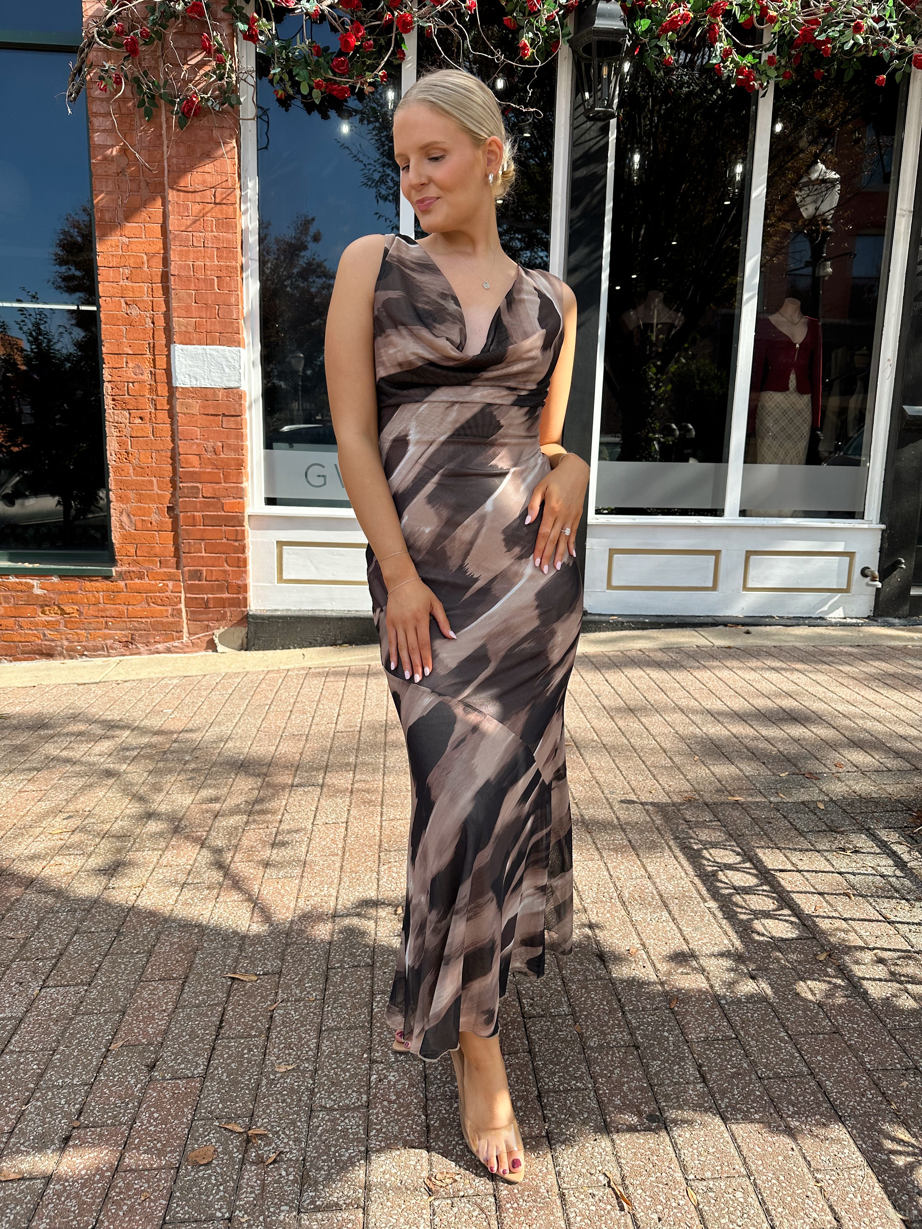 Woman wearing brown abstract pattern mesh midi dress with cowl neck and open back.