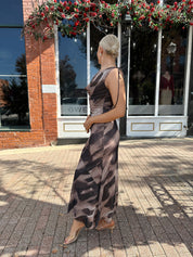 Woman wearing brown abstract pattern mesh midi dress with cowl neck and open back.