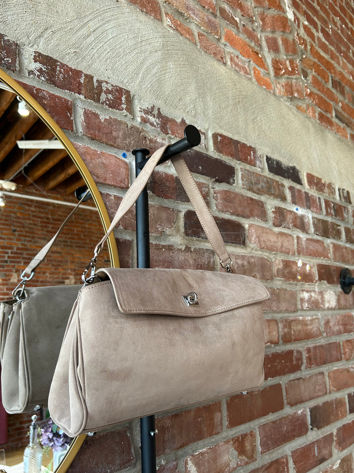 Beige suede shoulder bag with metal hardware and removable shoulder strap.