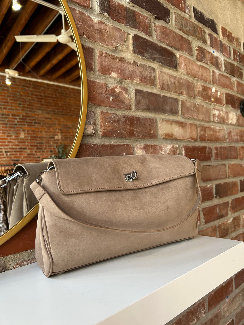 Beige suede shoulder bag with metal hardware and removable shoulder strap.