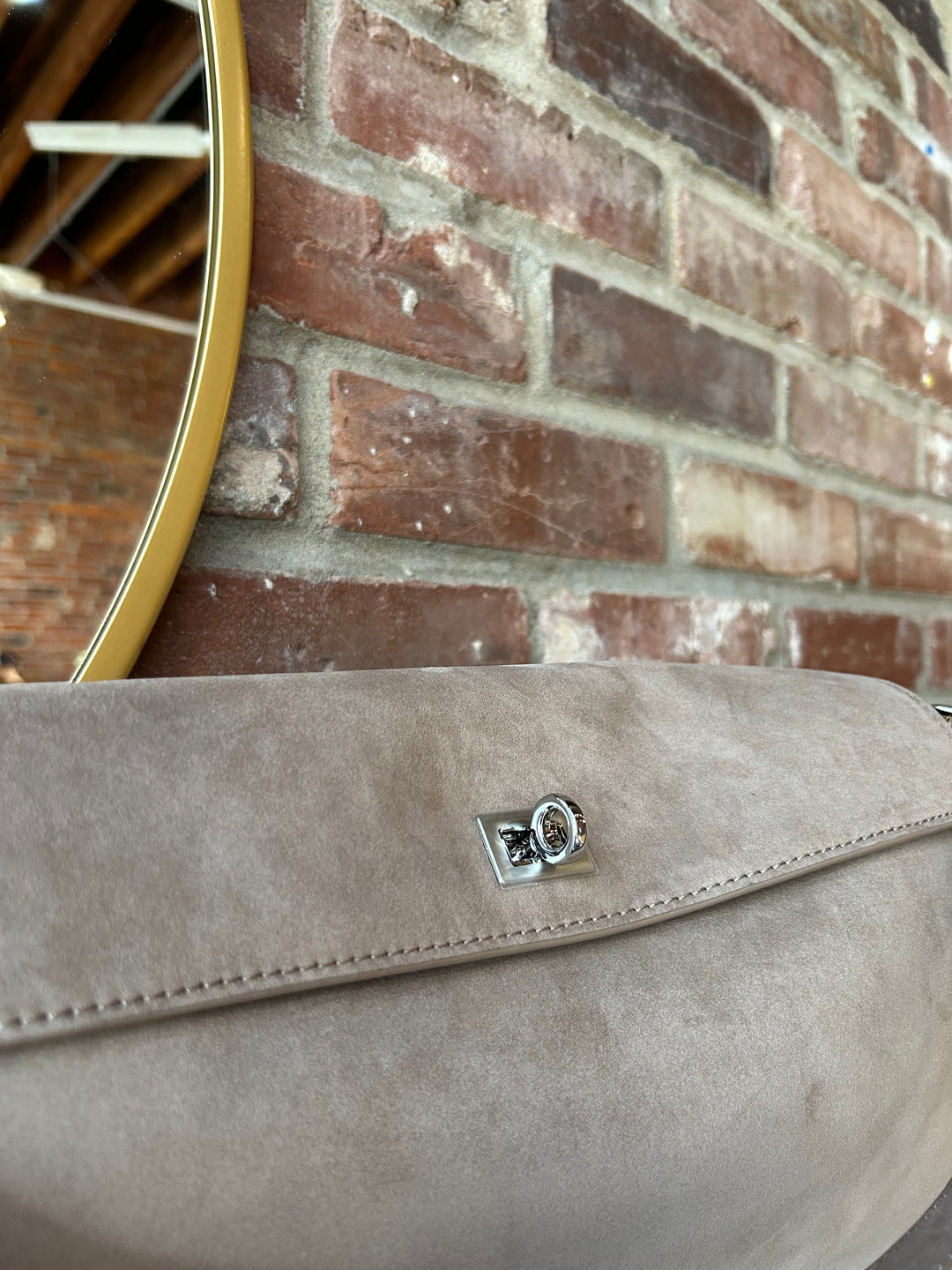 Beige suede shoulder bag with metal hardware and removable shoulder strap.