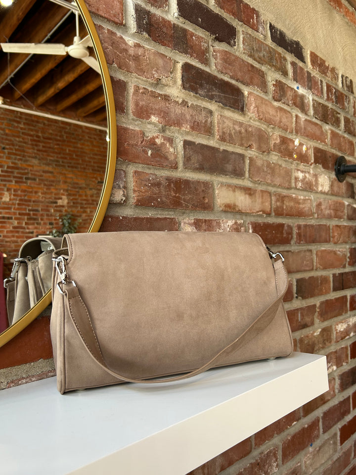 Beige suede shoulder bag with metal hardware and removable shoulder strap.