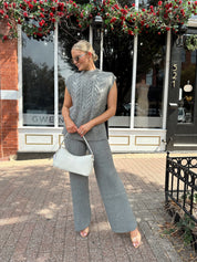 Woman wearing dark grey cable knit two piece sweater set with wide leg pant. 