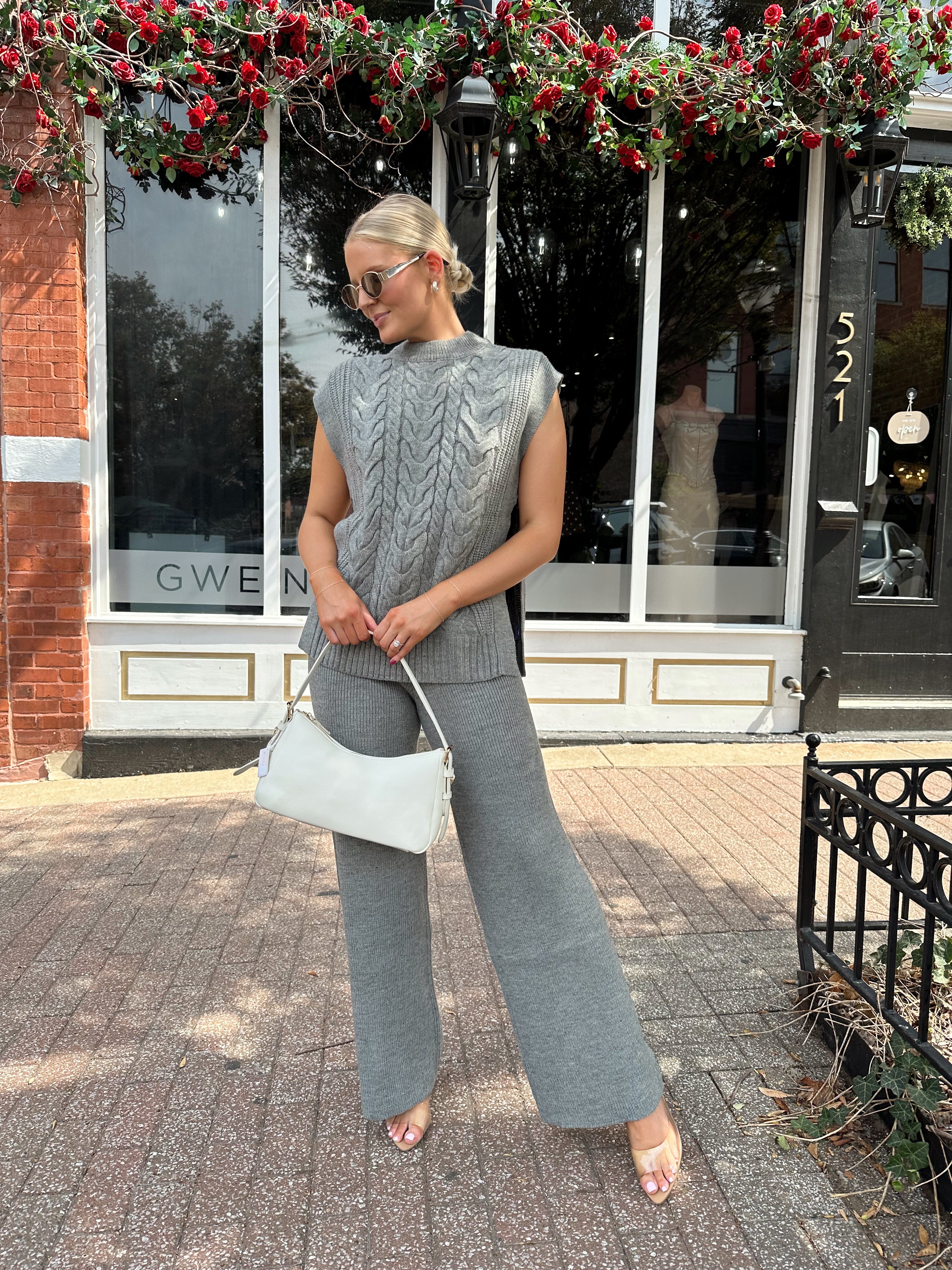 Woman wearing dark grey cable knit two piece sweater set with wide leg pant. 
