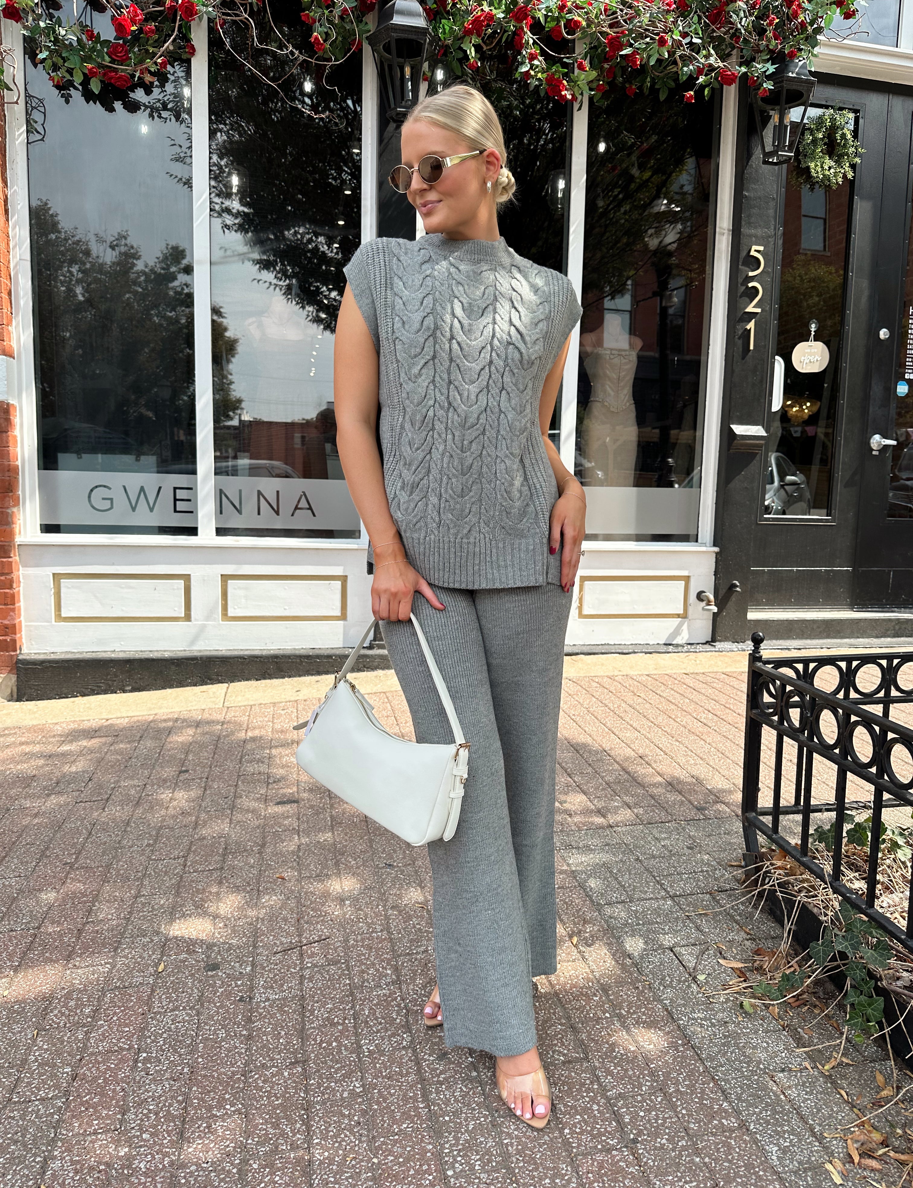 Woman wearing dark grey cable knit two piece sweater set with wide leg pant. 