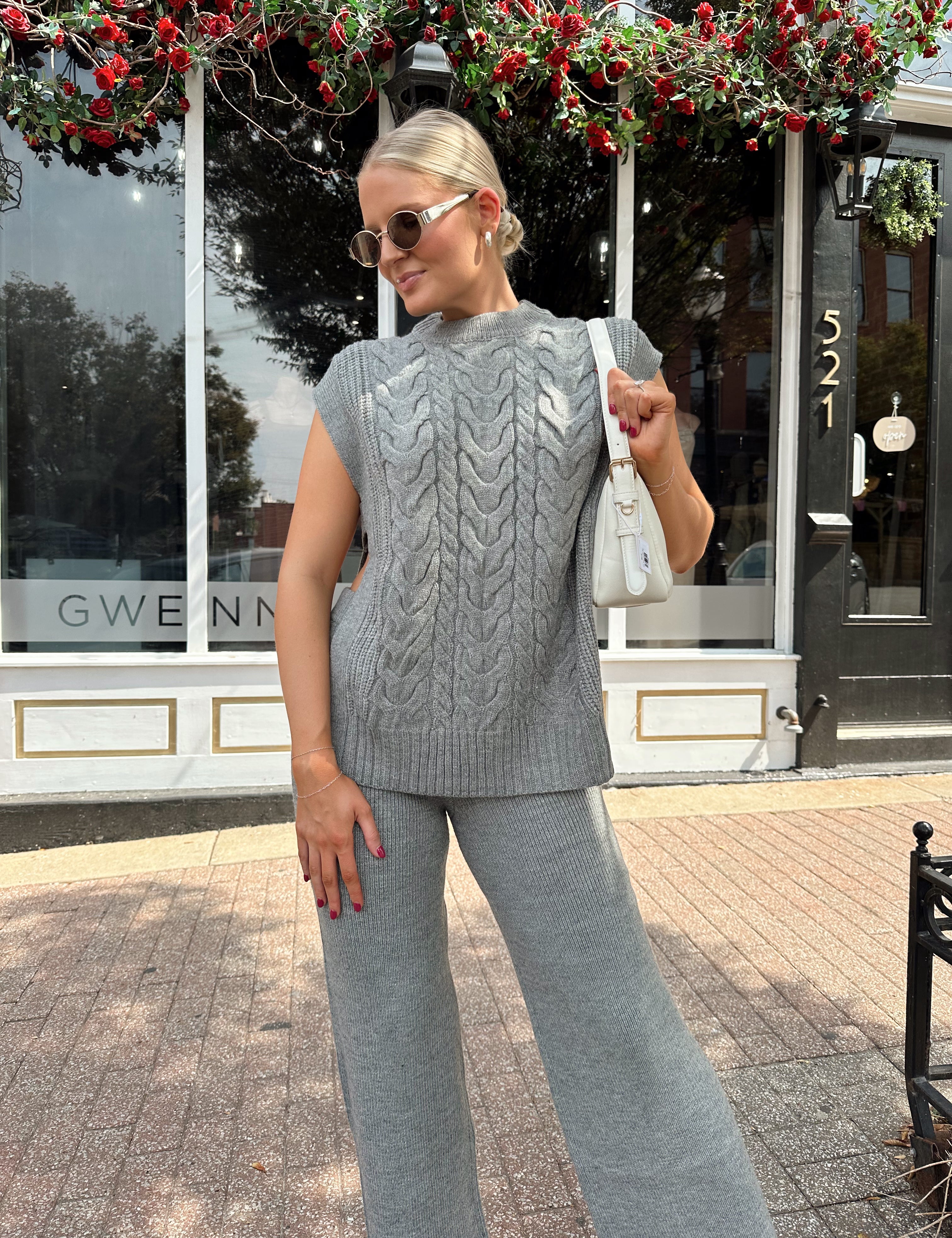 Woman wearing dark grey cable knit two piece sweater set with wide leg pant. 