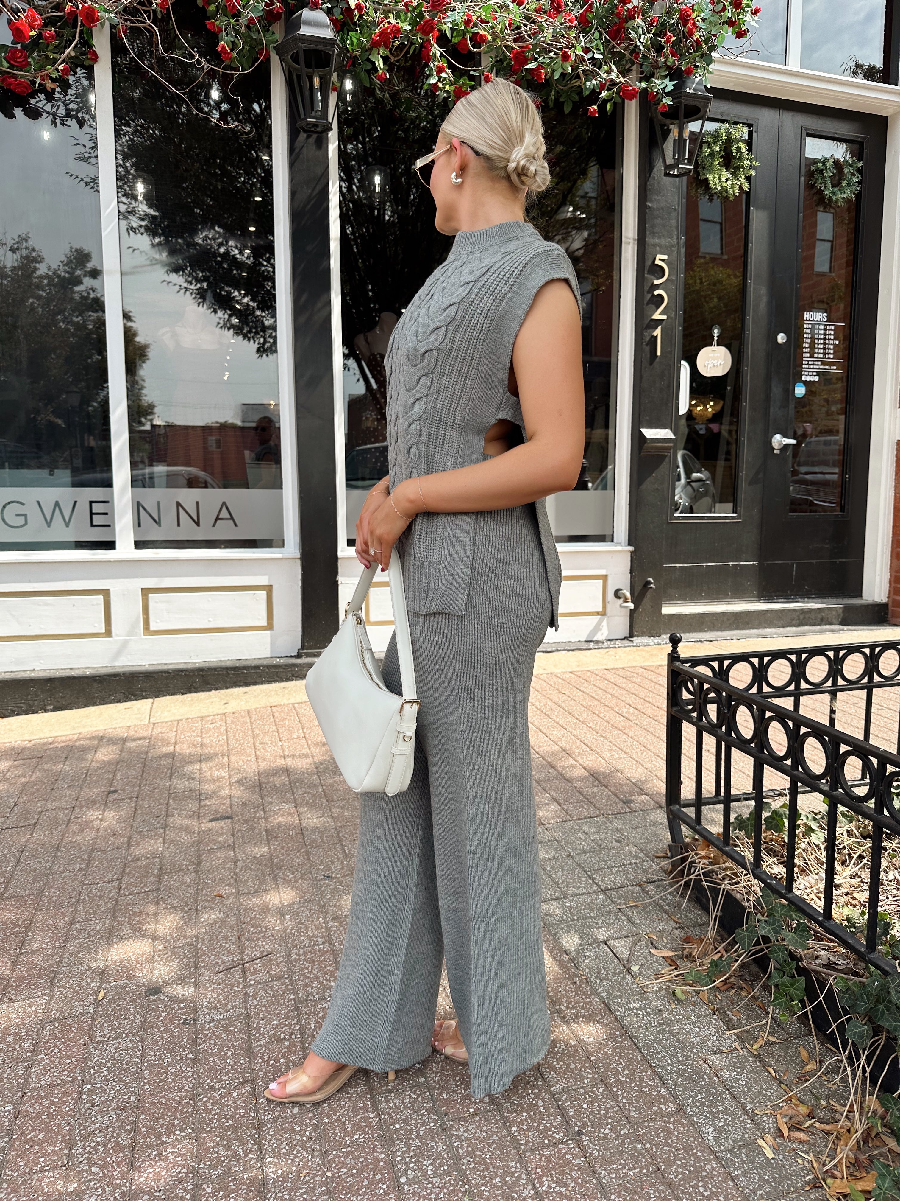 Woman wearing dark grey cable knit two piece sweater set with wide leg pant. 
