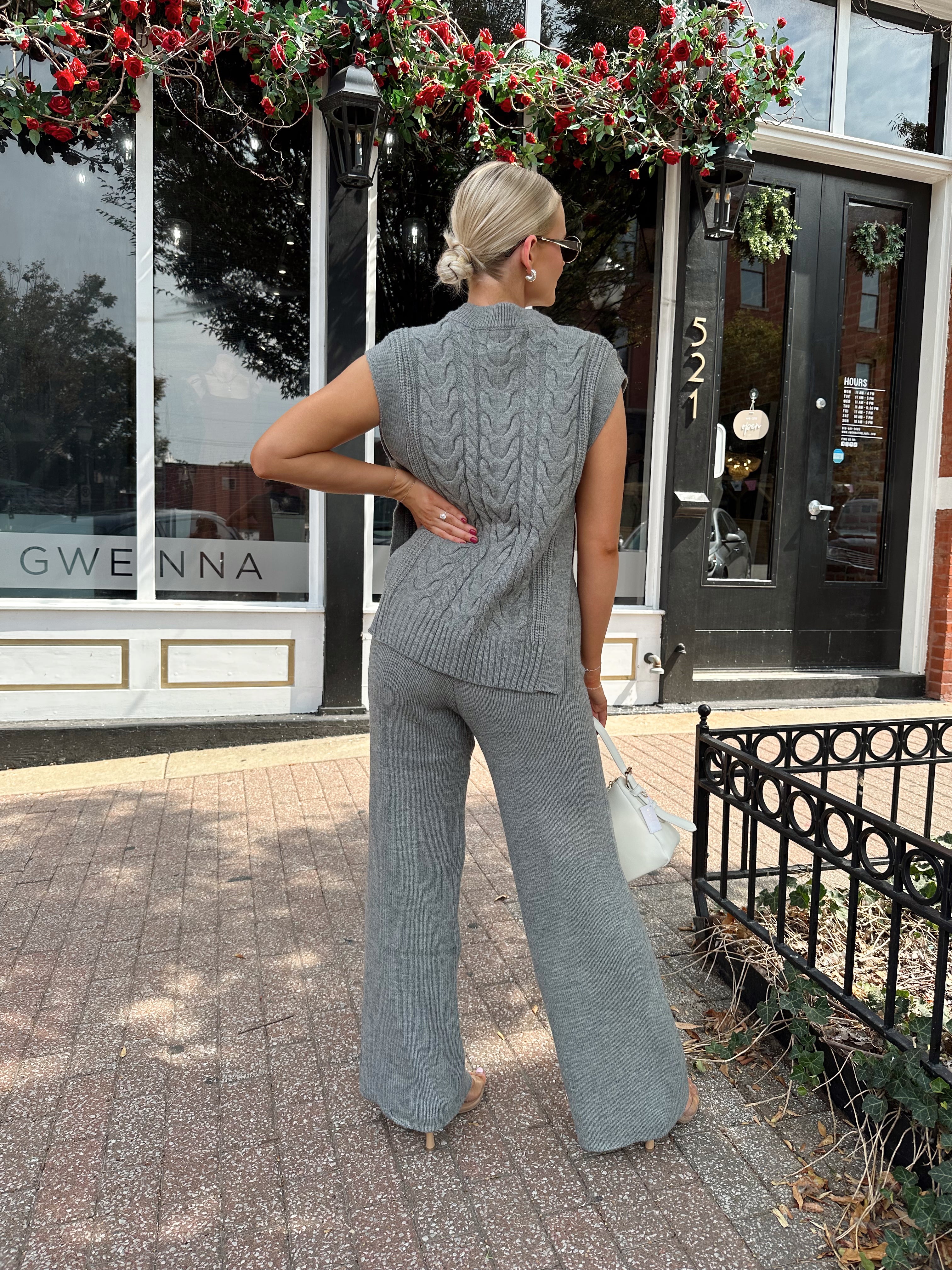 Woman wearing dark grey cable knit two piece sweater set with wide leg pant. 