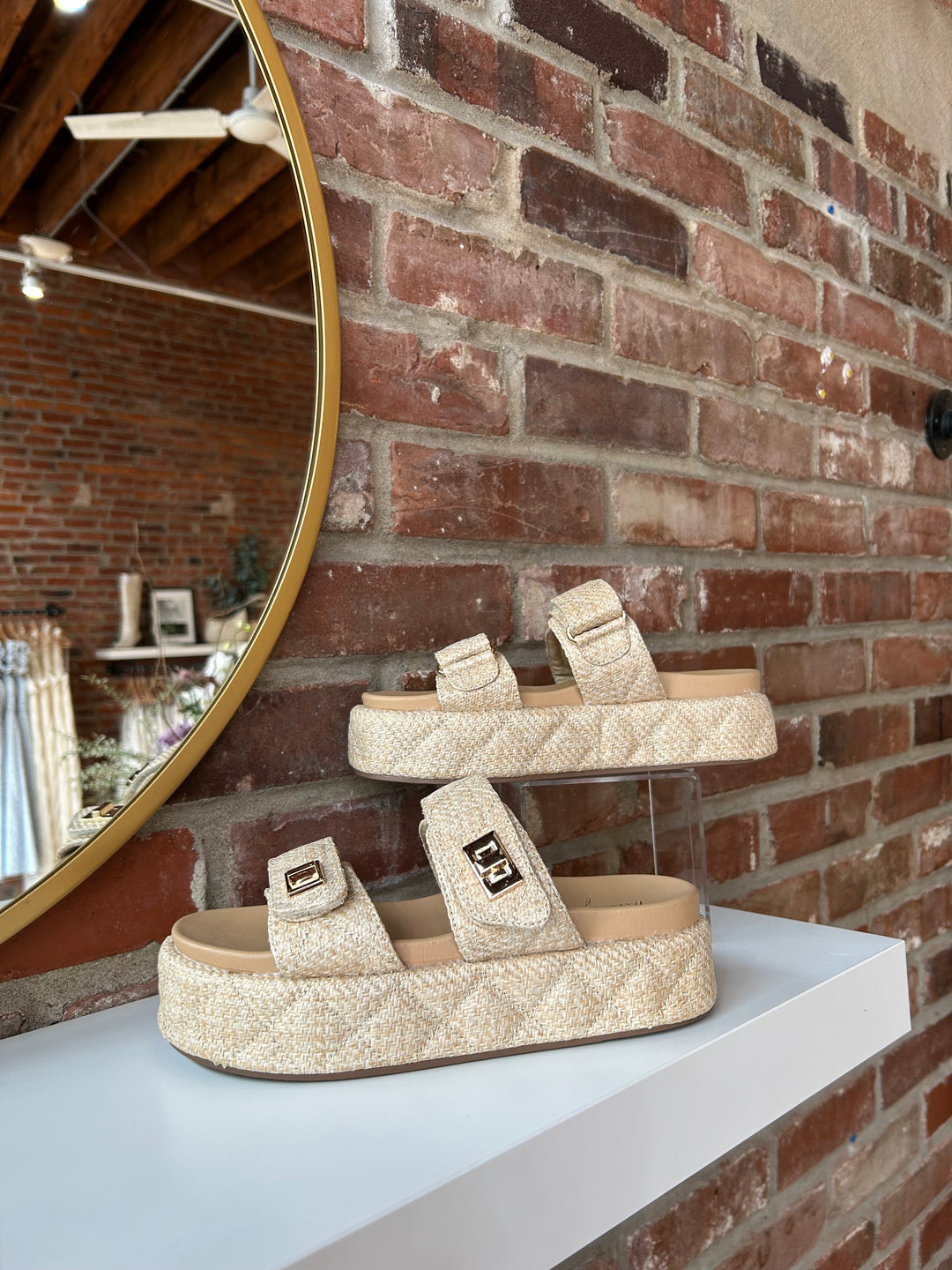 Quilted platform slide on sandals with gold hardware detailing.
