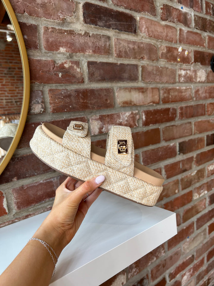 Quilted platform slide on sandals with gold hardware detailing.