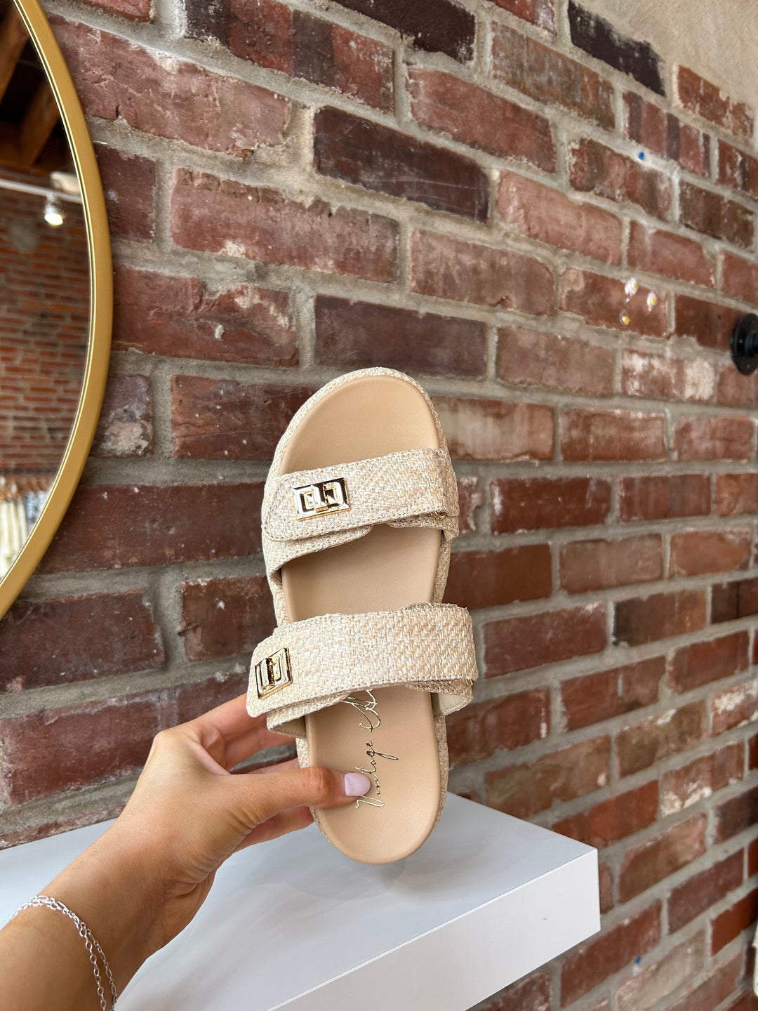 Quilted platform slide on sandals with gold hardware detailing.