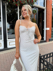 Woman wearing cream midi dress with blue floral pattern with lace trim detail. 