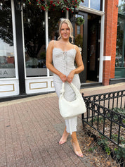 Woman wearing cream midi dress with blue floral pattern with lace trim detail. 