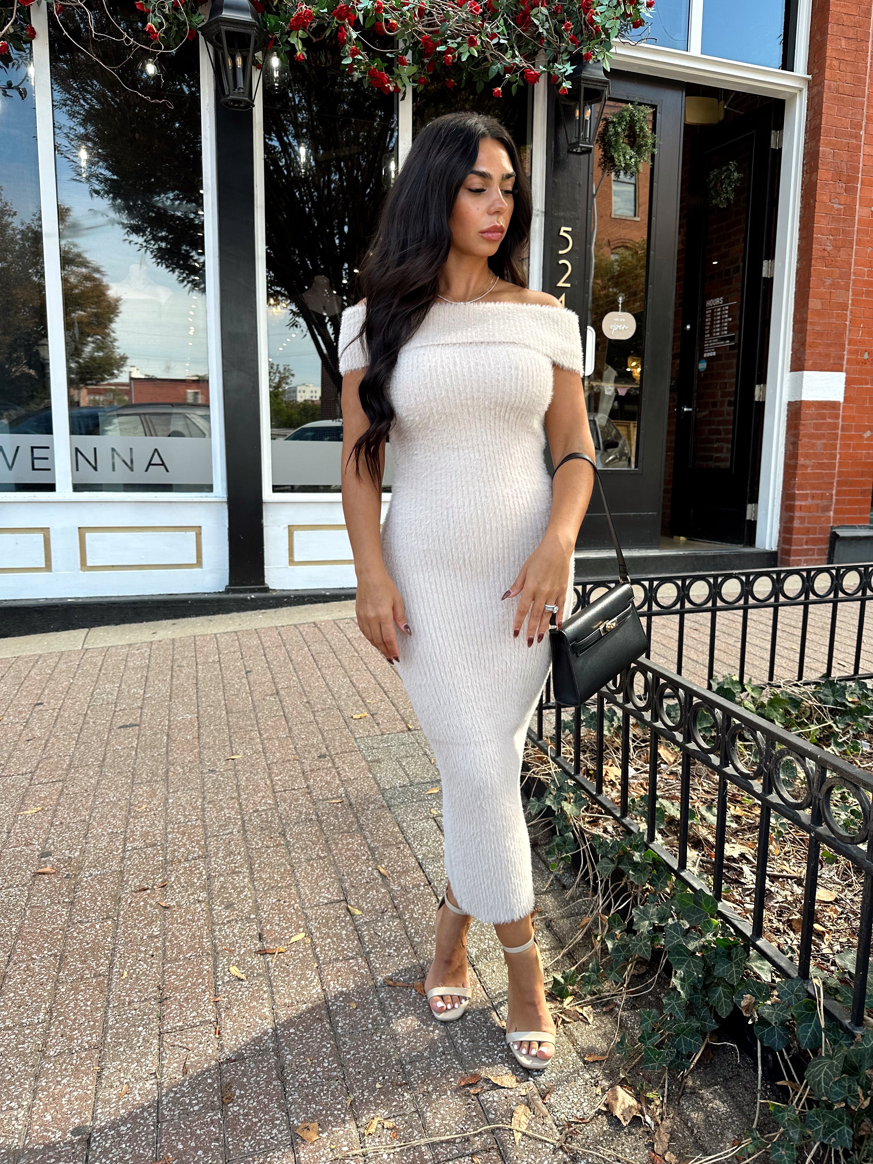 Women wearing cream colored furry off the shoulder midi dress.